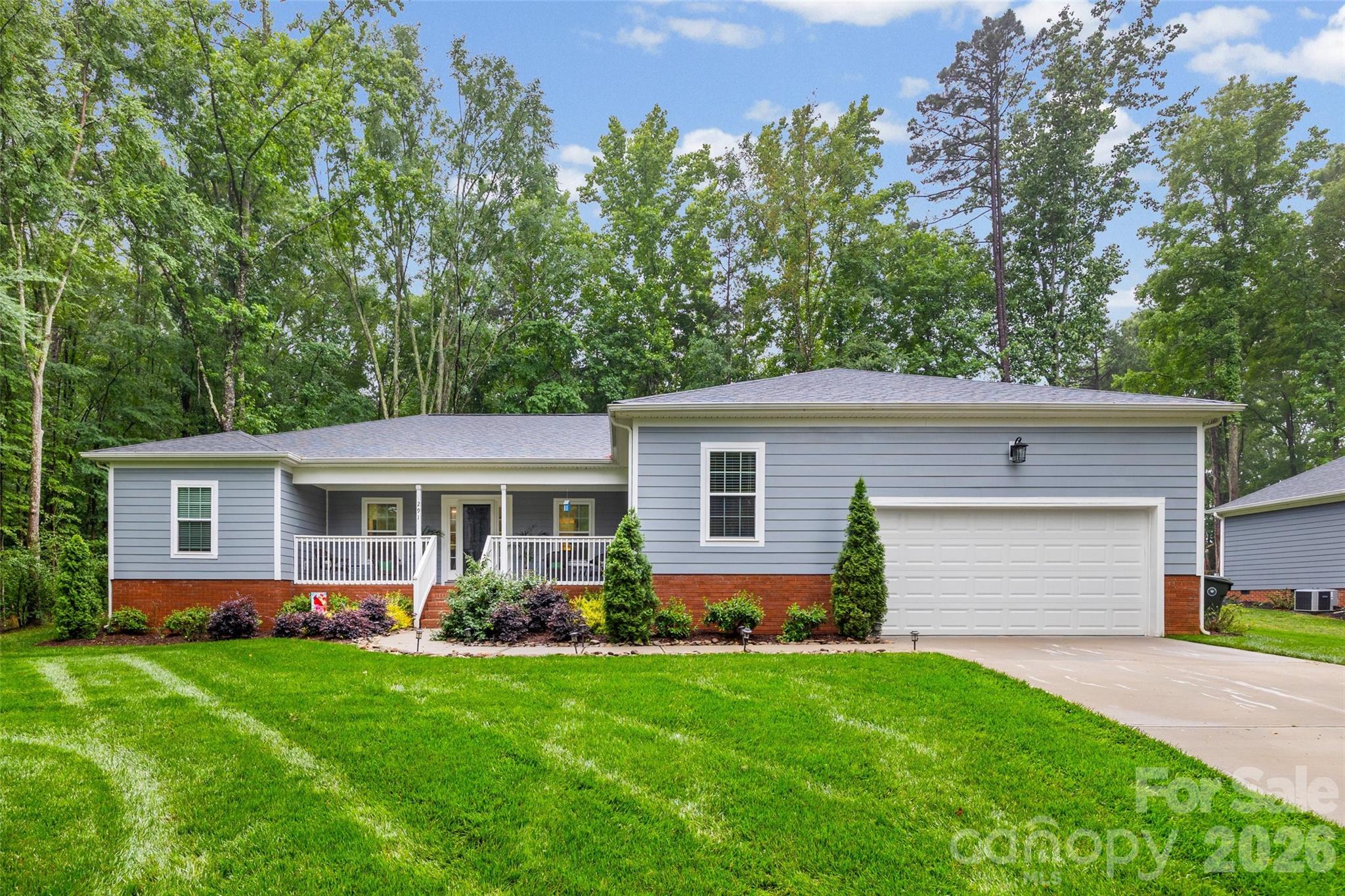 Imagine pulling up to this charming 2022-built ranch home, where a welcoming front porch and meticulous landscaping invite you inside to a bright, wide-open floor plan. The heart of the home centers around a beautifully designed kitchen featuring granite countertops, a tiled backsplash, and a massive breakfast bar that effortlessly handles a crowd—perfect for casual morning coffee or hosting weekend get-togethers. The main living space feels airy yet cozy, anchored by a fireplace and wrapped in modern finishes like wide-plank flooring and recessed lighting. Designed with a split-bedroom layout for maximum privacy, the primary suite serves as an exceptionally spacious retreat, complete with an elegant tray ceiling, a generous walk-in closet, and a pristine bathroom featuring dual sinks and a tiled shower. Everyday convenience is built right in, from the large laundry room with a dedicated sink to the extra storage room that can double as a flex space. Step out back to find your own private escape: a peaceful screened porch that opens to a grilling patio and a lush yard. Sitting on over half an acre with a secure, thoughtfully configured fence and backed by mature trees, you have plenty of room to play, garden, or simply unwind.