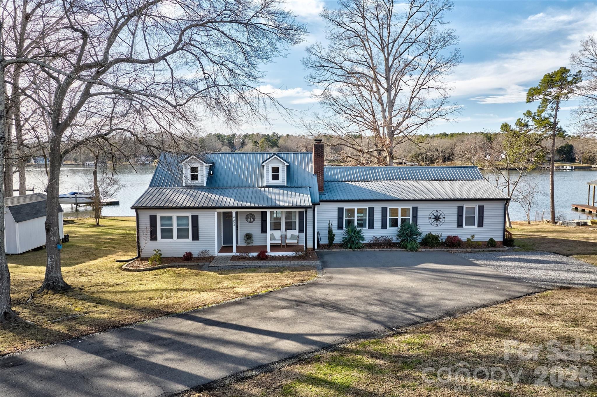 Wow remodel and main channel long range views on this home!  Located in the heart of Lake Wylie and not far from the bridge , this 3/4 acre flat lot with over 185 feet of water frontage with amazing views & sunsets, has a floating covered dock with a lift!  First floor has been opened up for several living spaces, a flex space/playroom or office, primary bedroom and bathroom suite and kitchen that calls for gatherings with expansive counters, oversized  island and dining room.  Upstaris offers 2 bedrooms and a bath.  Sellers have great taste and good workmanship on the update and remodel.  Huge window over the sink to enjoy the views and not block them.  The entire length of the back of the house is deck or screened porch.  You won't miss a minute of outdoor living with this home.  Garage can be easlly be added.  There is parking pad for your RV too! Shed for all your extra stuff storage also. Yard is fenced except for the gate.  Sellers took it off to get their RV in yard but could be re installed..  The dock has swimming ladder for easy in and out of water access.  Come enjoy the summer and lakefront living and no hills to traverse to get to your boat!  Welcome home! We appreciate buyer agents!  Please note this home is zoned for the new Lake Wylie High School for fall 2026 enrollment.