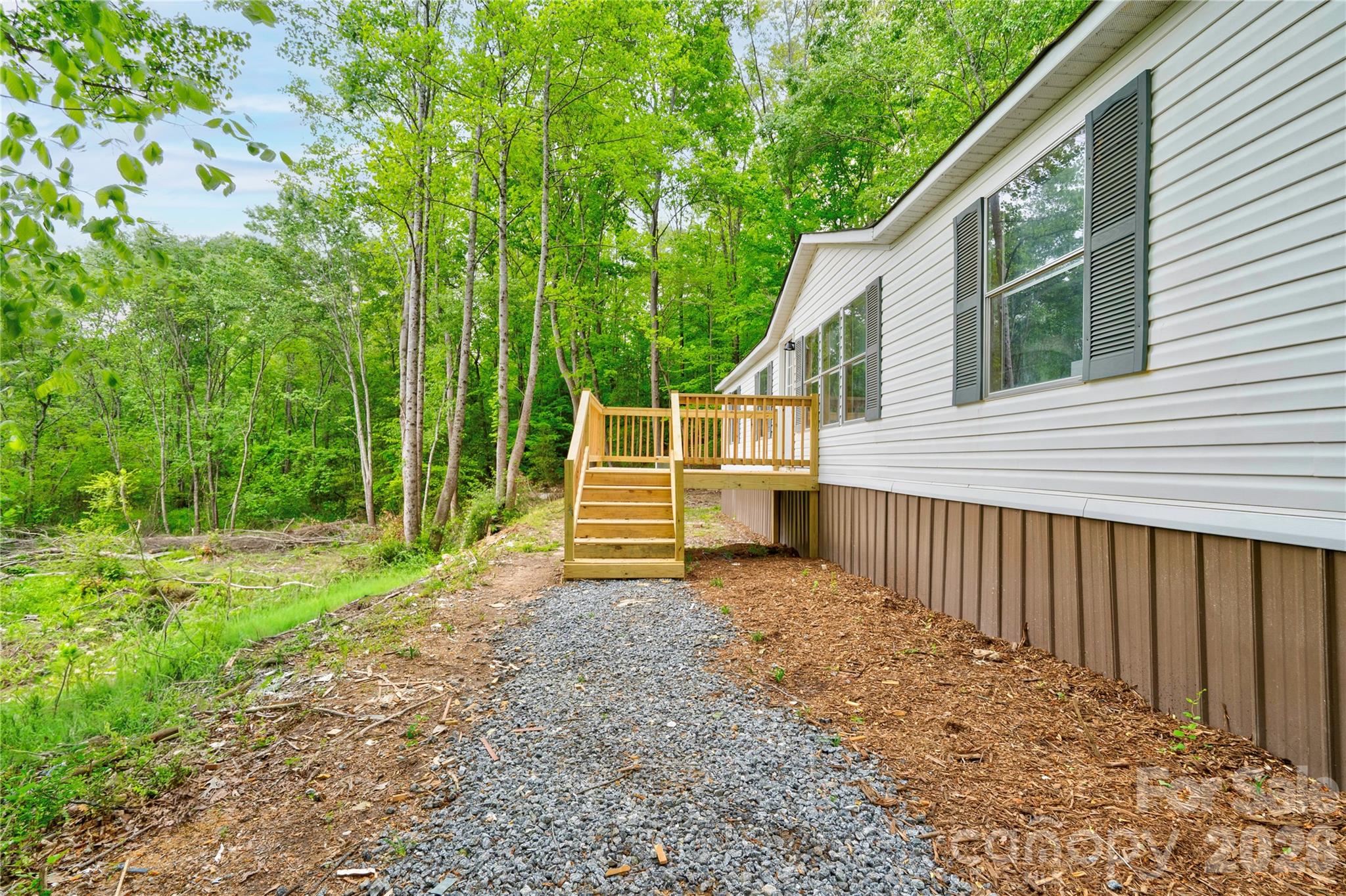 This beautifully updated 3-bedroom, 2-bathroom double wide offers the perfect opportunity for those seeking space, privacy, and a true escape from the hustle and bustle. Tucked well off the road, the home is not visible from the street, creating a peaceful and secluded setting surrounded by nature.The home has been thoughtfully updated and features new flooring throughout, fresh interior paint, an updated kitchen and bathrooms, a new HVAC system, and a new roof. A freshly graveled driveway leads you into the property, adding to both functionality and curb appeal. The land offers a unique blend of usability and natural landscape, with a portion located within a floodplain.  Conveniently located approximately 25 minutes from Shelby, this property provides the perfect balance of rural living with access to nearby amenities. If you’ve been searching for acreage, privacy, and an updated home, this is one you don’t want to miss!