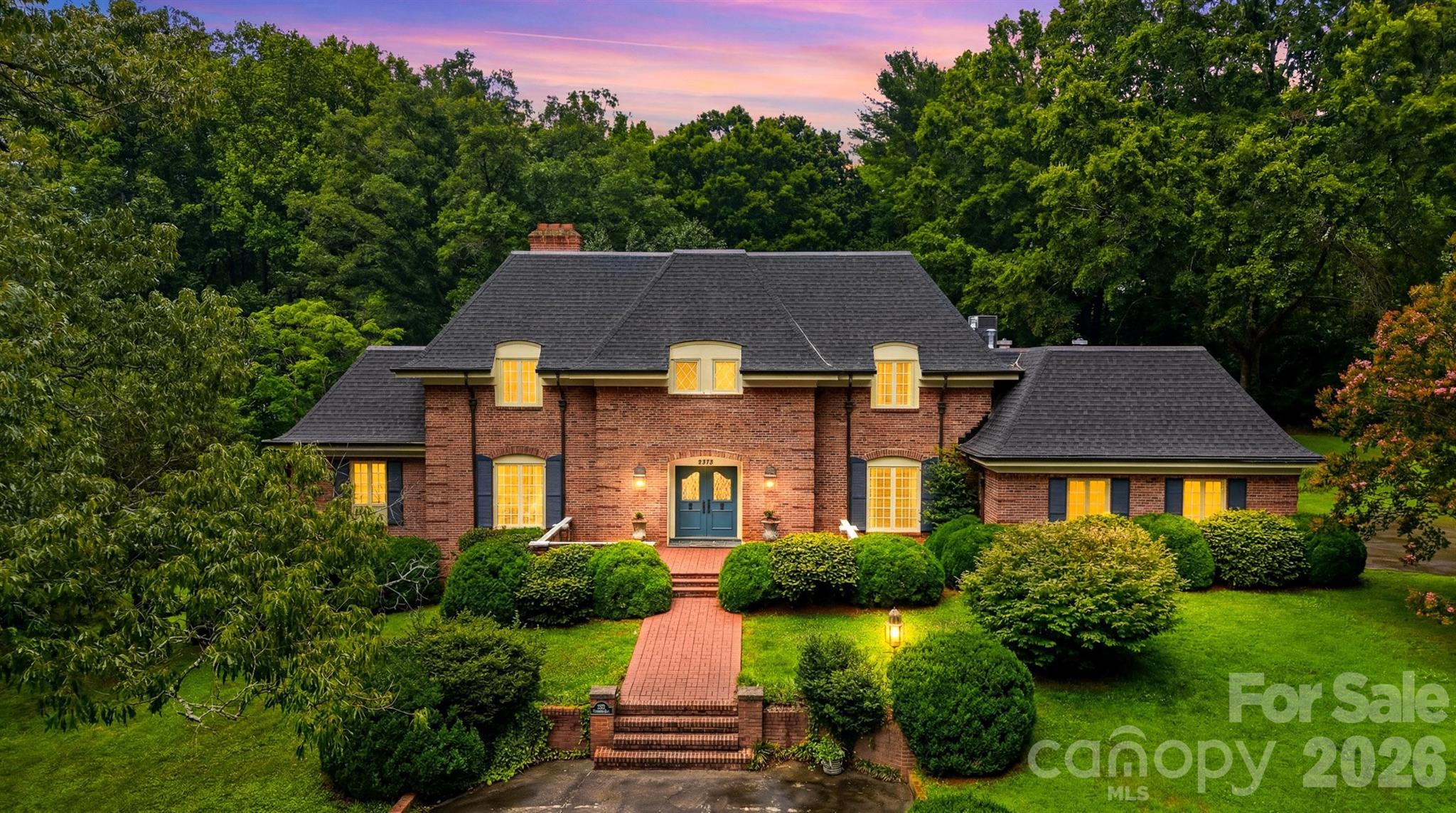 Experience timeless craftsmanship in this exceptional one owner, custom-built estate by renowned builder Raymond Edwards. Privately situated on 3.81 acres, this remarkable property offers exceptional privacy.

From the moment you step into the grand foyer, you'll be captivated by soaring ceilings and an elegant curved staircase that creates a truly unforgettable first impression. With 10-foot ceilings, decorative moldings and beautiful hardwood floors throughout most of the main level, every space reflects quality craftsmanship, timeless elegance, and thoughtful design.

The main level offers an ideal balance of sophistication and everyday living, featuring a formal living room with a fireplace, an inviting den with a second fireplace, a spacious kitchen with a casual dining area, a formal dining room perfect for hosting family and friends and a beautiful sunroom that provides a peaceful space to relax while taking in views of the surrounding property. The private owner's suite is conveniently located on the main level and includes the primary bedroom, full bath, and adjacent laundry room. A guest half bath completes the main floor.

Upstairs, you'll find two generously sized bedrooms, a full bath, and a dedicated office that could easily serve as an additional bedroom. While the septic permit is for three bedrooms, the home was thoughtfully designed to accommodate a fourth or fifth bedroom by simply adding a wall to divide the oversized bedroom. An additional room off of the hall is already plumbed for a future full bathroom, while an expansive walk-in attic space provides even more storage.

The walkout basement offers incredible flexibility for future expansion. The finished area features a charming wood-burning fireplace and is already plumbed for both a kitchen and full bath, making it ideal for a guest suite, recreation room, or multi-generational living. The unfinished portion provides ample space for a workshop, additional storage, or extra garage parking. Abundant closets and storage throughout the home ensure there's a place for everything.

Outside, a beautifully designed courtyard creates a peaceful retreat, complete with four raised garden beds that add both charm and functionality to the outdoor living space. The expansive grounds provide the perfect setting for enjoying nature, gardening, or simply relaxing in complete privacy.

Located just down the street from Cedar Rock Country Club, members enjoy access to an Ellis Maples-designed 18-hole championship golf course, driving range, four CaliClay tennis courts, a swimming pool, dining, and a variety of additional club amenities. 

Combining timeless architecture, exceptional craftsmanship, remarkable privacy, and an outstanding location, this extraordinary estate presents a rare opportunity to own one of the area's premier properties.
