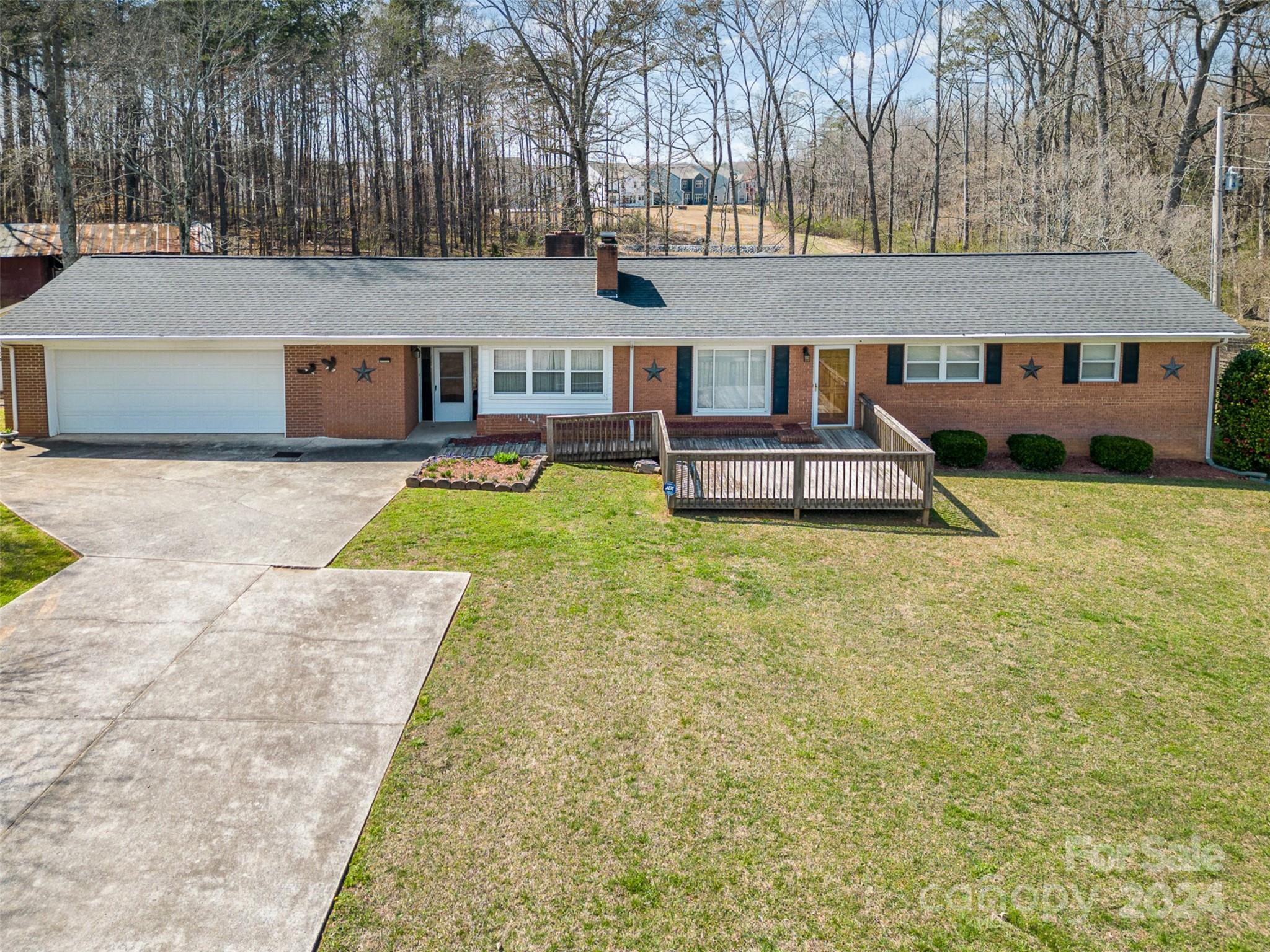 Spacious Full Brick Ranch home on large 2.27 acre lot. Own and Update your own private retreat! Home sits with private tree lined backyard plus tons of flat cleared green space on all sides providing you tons of potential. Home has been well maintained while it could use some updating, has tons of space ready to call your own. Enter in off of front deck area into living room with one of 2 gas fireplaces. Living room opens to dining room w/ sliding glass door leading to large sunroom perfect for all seasons. Kitchen has side counter area for additional space and leads into the family room w/ 2nd fireplace. Additional bonus room beside garage for even more space! Primary bedroom w/ attached half bath plus 2 additional bedrooms w/ full hall bath for family & guests. Large storage unit plus barn on property for extra space. 2 car garage plus oversized driveway provides plenty of parking. Home is just 10 minutes from downtown Monroe w/ tons of local shops, restaurants and grocery stores!
