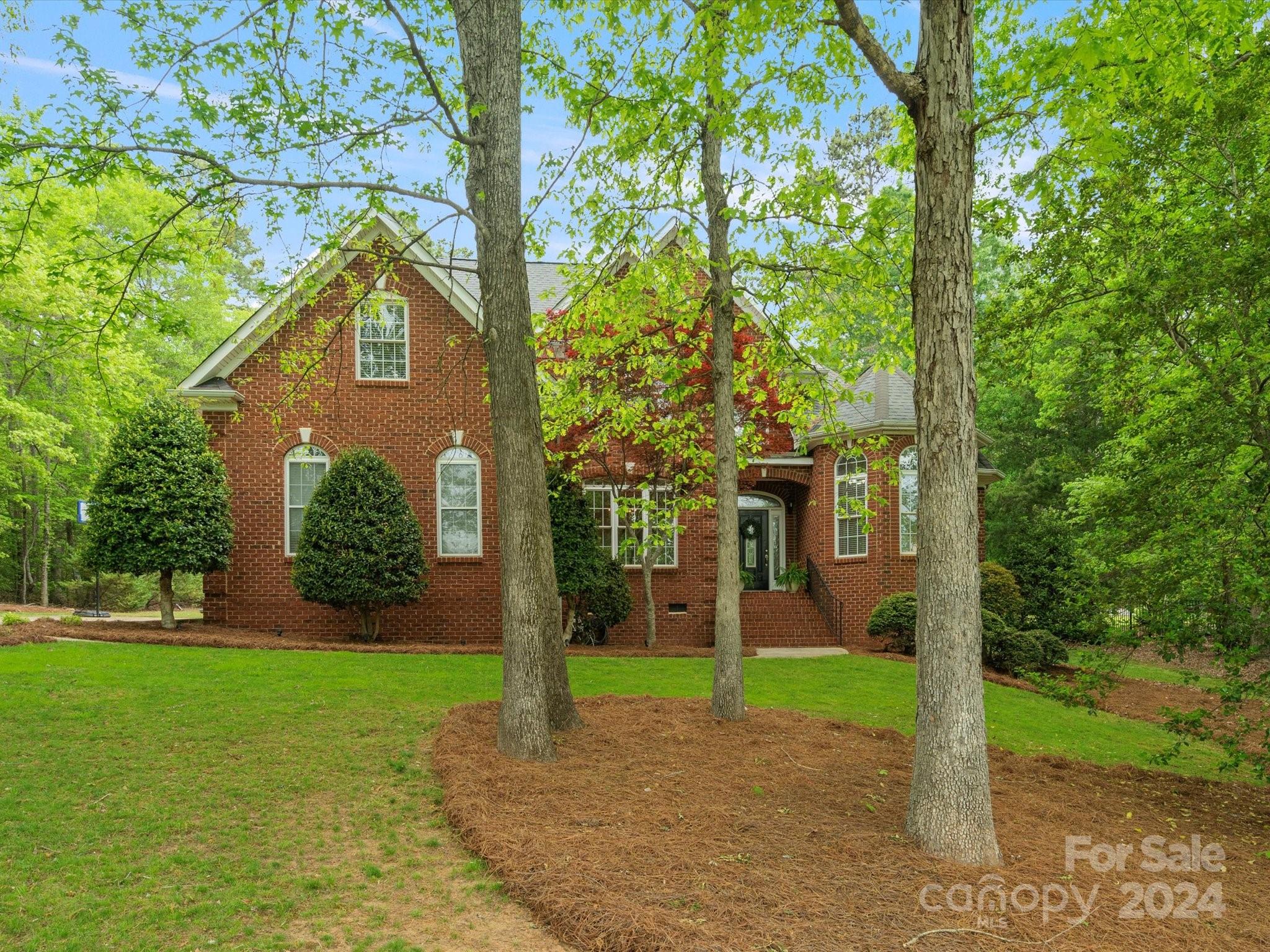 Nestled among tall hardwood trees on a generous 1.12 acre lot, this custom brick home offers a rare blend of privacy & tranquility in the desirable Beckenham neighborhood. Soaring two-story greets you w/natural light & light colored floors. The vaulted great room radiates timeless charm w/its pristine white brick fireplace, seamlessly connecting to the spacious kitchen adorned w/SS appliances, granite counters, farmhouse apron sink and functional island. Tucked around the corner you'll find 1st floor guest BR currently used as an office. Retreat to the main-level primary suite, featuring a bay window, intricate crown molding, and a luxurious ensuite bath w/ separate his/her sinks, a garden tub, & walk-in shower w/dual shower heads. Upstairs, two additional bedrooms & a spacious bonus room await. Step outside to unwind on the expansive deck or sway gently in a hammock, enveloped by complete privacy of towering hardwoods. Fort Mill Schools with the newest HS, Catawba Ridge!