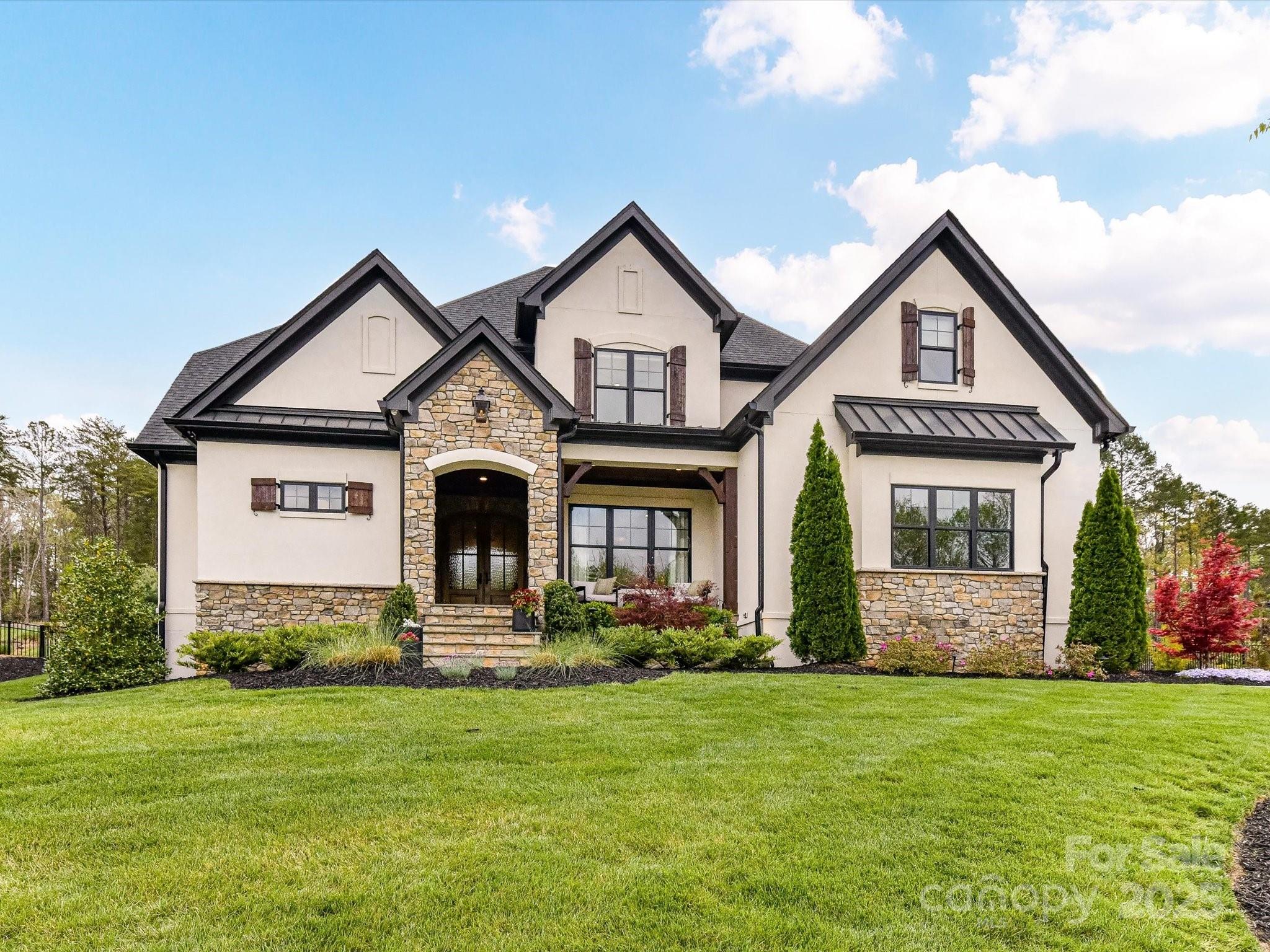 Looking for luxury in Fort Mill? Look no further! Welcome to this fabulous 5bd/4bth home in The Ridge at Fort Mill, where elegance and comfort blend seamlessly on a 1+ acre lot. With over 4,100 sq. ft. this custom-built luxury property features vaulted ceilings with accented beams, an open-concept design that’s both inviting and functional, and a can't miss ceiling detail in the kitchen! Designed for both entertaining and everyday living, the chef’s kitchen boasts Sub-Zero/Wolf/Cove appliances, an oversized island, and scullery. The owner’s suite offers a serene escape with a spa-like primary bth, soaking tub, and expansive walk-in closet. Step outside to your personal paradise, featuring a covered porch with retractable screen, fireplace, and overhead heaters for year-round comfort. The saltwater pool/spa, outdoor kitchen, and shower complete this exceptional outdoor retreat, all set within a fully fenced and beautifully landscaped backyard. This is more than a home—it’s a lifestyle!