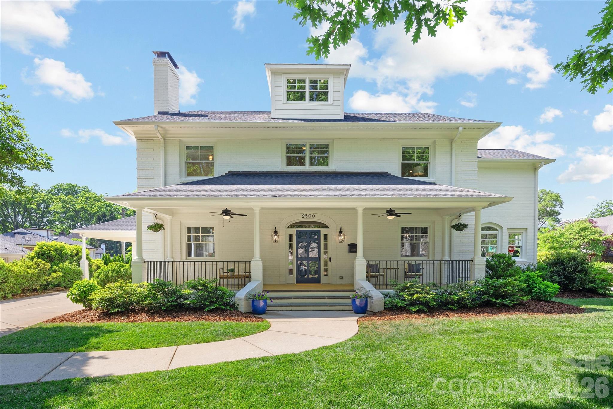 Situated on a corner lot in the heart of Myers Park, this wonderfully updated residence blends timeless character, modern functionality and amazing entertaining spaces inside and out. The stately painted brick home with classic rocking-chair front porch offers 5 bedrooms, 4 baths, and 4,790 square feet across an open floor plan. It features beautiful hardwoods, 9’ ceilings on main level, formal living and dining rooms, and a sunroom ideal for a home office. The updated kitchen boasts white quartz surfaces and backsplash, dual Thermador ovens, Sub-Zero refrigerator, and opens to versatile living spaces designed for everyday living and entertaining. The two-car porte-cochere provides covered side entry access to updated mud room featuring custom cabinet storage and an additional full-size fridge/freezer. Upstairs, the serene primary suite offers a walk-in closet and a renovated spa-like bath, along with three additional bedrooms, spacious laundry room, and flexible fifth bedroom (currently outfitted as a home gym). The finished third level adds 800+ square feet of bonus room with matching hardwoods and finishes, while retaining ample storage space. Outdoor living is exceptional—professionally designed with fully-fenced turf backyard, a covered bluestone patio that extends to the showcase outdoor fireplace and entertaining area with mounted TV, built-in gas grill, matching ceramic charcoal grill, and beverage fridge. A custom 2023 detached garage with extensive attic storage completes this impressive home. Ideally located moments away from shops, restaurants, parks & Uptown - this is one you don’t want to miss!