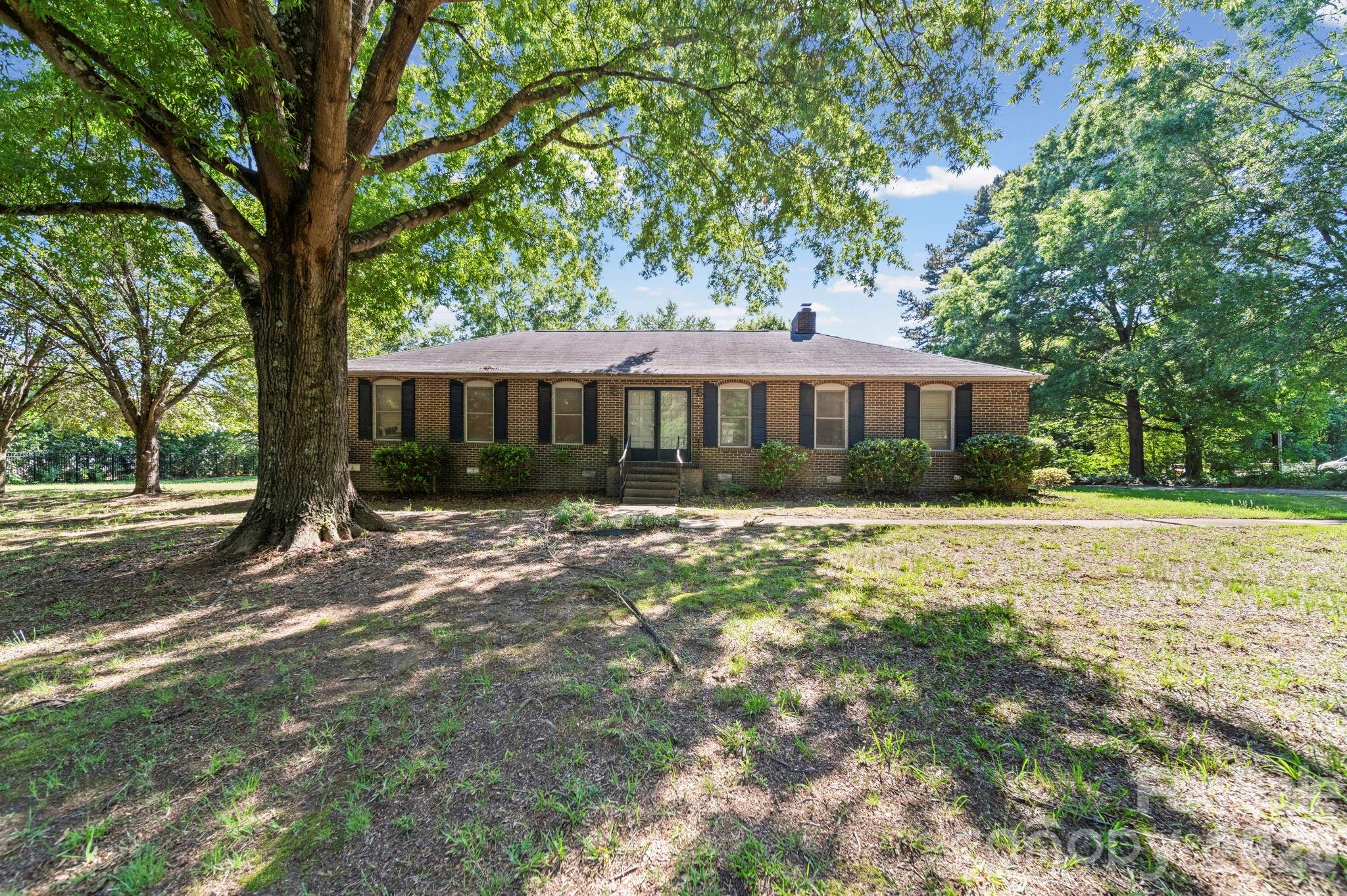 Discover the potential of this full brick ranch situated on a 1.11-acre lot in a highly desirable Davidson location near an entrance to River Run. Offering a peaceful, country-like setting while remaining convenient to all that Davidson has to offer, this property presents a unique opportunity for homeowners, investors, or those looking to create their dream home. Inside, the spacious great room features a cozy wood-burning fireplace and provides an inviting gathering space. The large kitchen offers abundant counter space, ample cabinetry, and a breakfast nook overlooking the private backyard. The primary suite includes a private bath, while two additional generously sized bedrooms share a full hall bathroom. Outside, you'll find a detached two-car garage plus a detached carport with an extensive attached storage area, providing exceptional space for vehicles, equipment, hobbies, or workshop needs. The expansive lot offers room to garden, play, or expand. With solid construction, abundant storage, and endless possibilities, this property is ready for its next chapter. Home is being sold as-is, and no repairs will be made by the seller. A rare opportunity to enjoy space, privacy, and flexibility in Davidson.