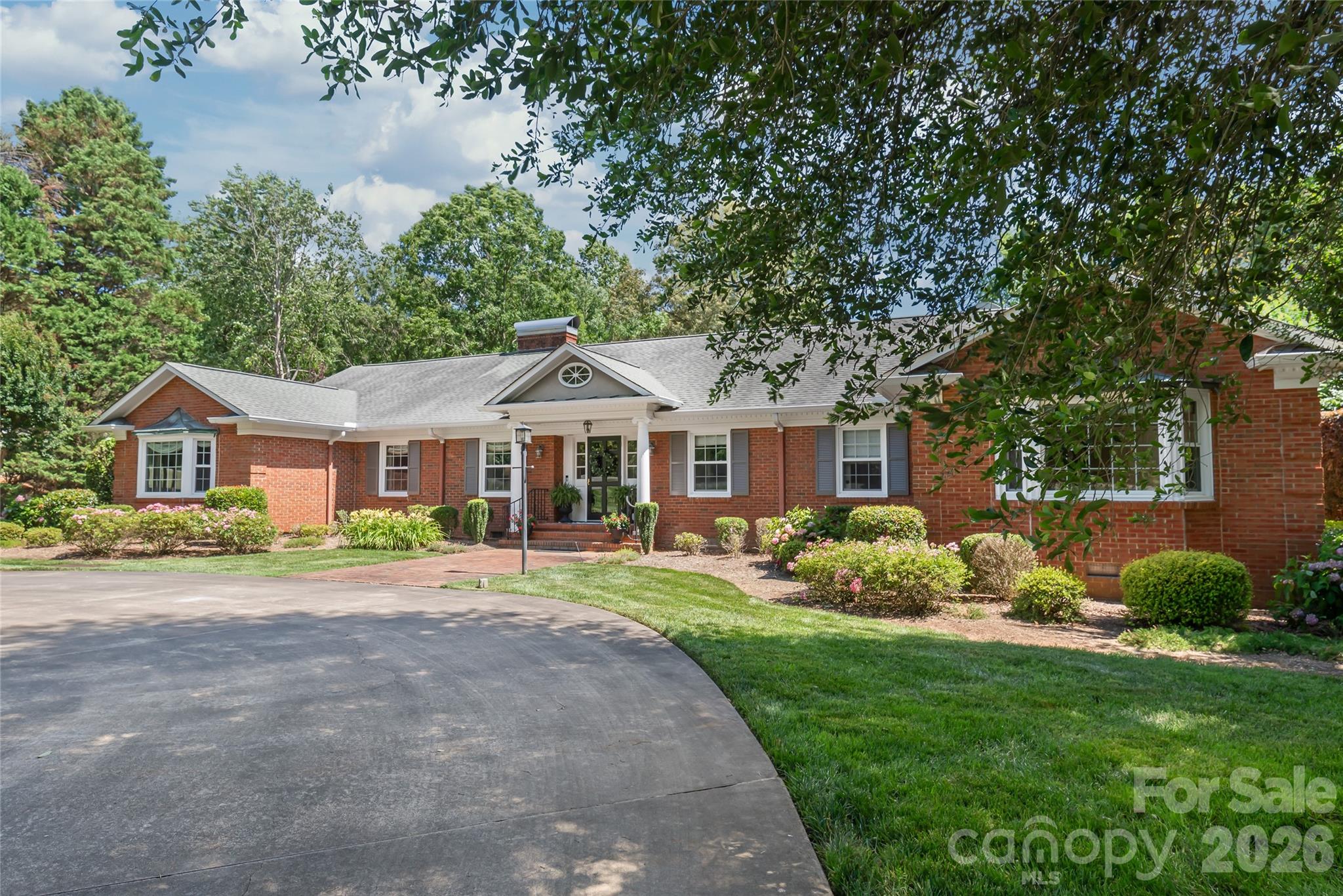 Opportunities like this are truly one-of-a-kind. Nestled on a premier 1.15-acre estate adjacent to the Fort Mill Golf Club, this full brick ranch offers a rare living experience that perfectly balances true character with modern conveniences...all while enjoying the ultimate luxury of NO HOA. From the moment you pull up the grand circular driveway, canopied by majestic, mature hardwoods, you realize this isn't just a home...it’s a private sanctuary.

Inside, the residence exudes warmth, featuring hardwood floors throughout, whole-house surround sound, and two cozy gas fireplaces designed for crisp evenings. The heart of the home features a beautiful kitchen equipped with a gas stovetop, timeless 42-inch cabinets, and a spacious walk-in pantry. The thoughtful layout offers 4 bedrooms and 3 baths, including a primary suite with a fully renovated bath. Everyday convenience is elevated by a large laundry room, complete with a utility sink and built-in cabinets for extra storage.

Enjoy peace-of-mind upgrades, including many updated windows and a high-efficiency tankless water heater. For the hobbyist, the side-load 2-car garage features a dedicated workshop and storage area.

The true magic unfolds in the grand great room, where views look out over an unparalleled, fully fenced backyard oasis. Here, days are spent lounging by the sparkling in-ground salt water pool, surrounded by an expansive, lush lawn kept vibrant by a private irrigation well. Hosting summer barbecues is effortless with a convenient outdoor gas hook-up ready for your grill. This is more than a place to live; it’s a quiet, historic oasis of land in the very heart of Fort Mill...minutes from top-rated schools, boutique shopping, and dining, yet worlds away from the everyday hustle. Own a piece of Fairway Drive's legacy.