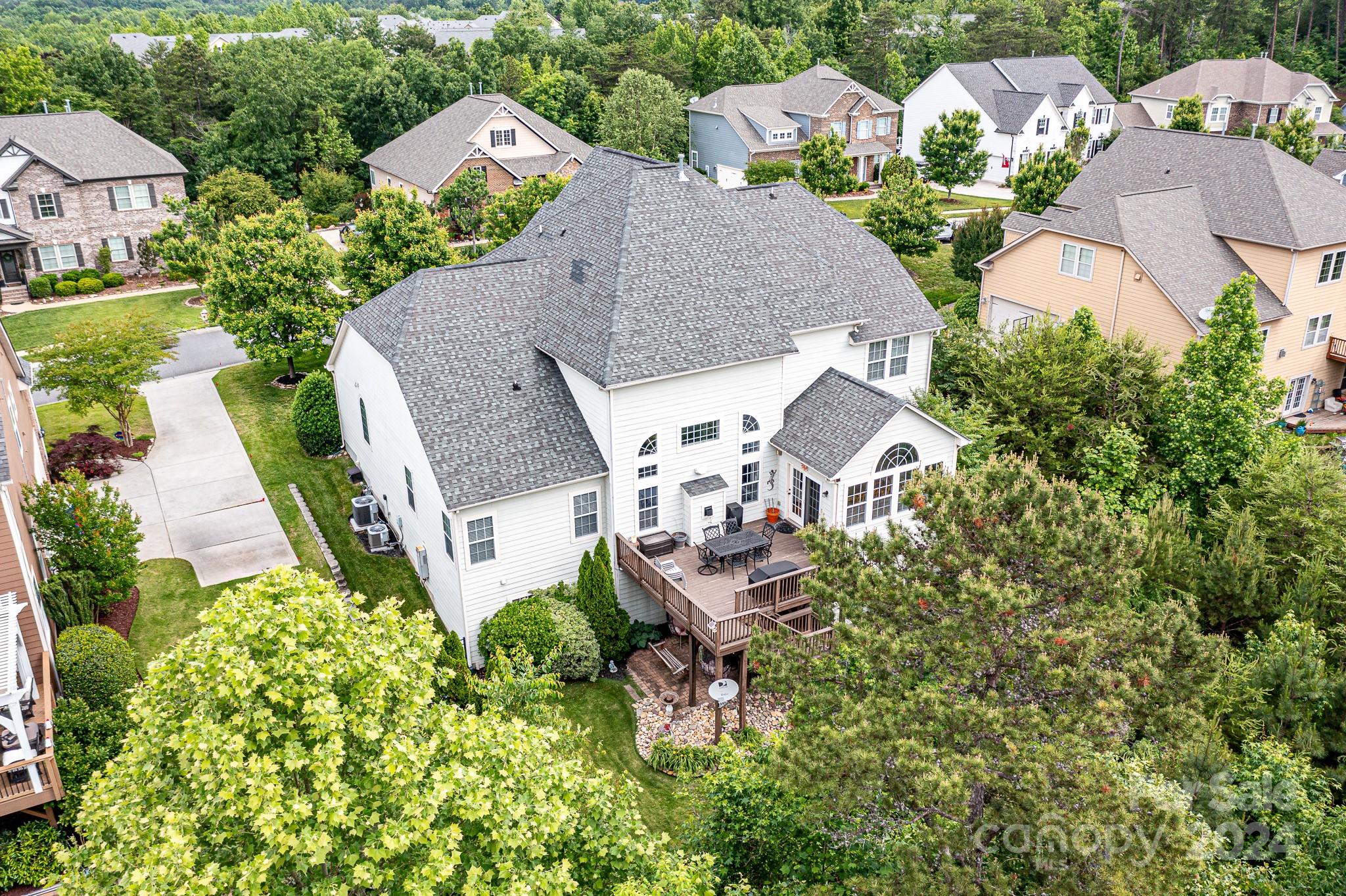 Gorgeous Stone accented 5 bedroom/ 4 1/2 bath home with a finished walk-out basement in the desirable Serenity Point community in Tega Cay. The grand great room has coffered ceilings, arched transom windows, surround sound ready and a butlers pantry. The main level also features an open floorplan, wall of windows overlooking the treelined backyard, laundry room with cabinets, breakfast area, office, dining room and large deck. The chefs kitchen is perfect for entertaining with a huge work island, gas cooktop, double ovens, SS appliances and a walk in pantry. Spacious Primary suite on main with garden tub, double sinks, and 2 walk in closets. Upper level features 3 large bedrooms, bonus room and 2 full baths. The finished basement is a fantastic entertaining space which includes a theater room, rec room with kitchenette/bar, bedroom and full bath. Fenced with an oversized 3 car garage. Sits on a quiet street in amenity rich Tega Cay. Award winning Fort Mill School district.