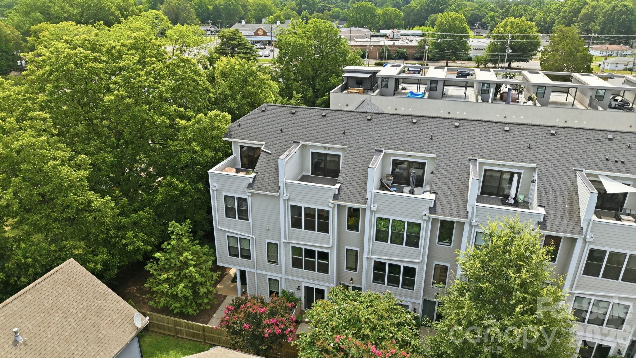 Tucked directly off of 36th Street within The Arts District boundary, this 2019-built contemporary townhome in the Terraces of 36th Street (one of seven) offers the ultimate in modern urban living.  Spanning over 2500 sf of bright, open spaces, this impeccably maintained townhome features 3 large bedrooms, a dedicated lower-level home office / flex space, 3 full baths and 1 half bath.  Move right in with total peace of mind - this home has been pre-inspected.  Featuring a sleek kitchen with stainless steel appliances, an abundance of countertop space, and cabinetry while anchored by a generously sized island.  The open concept floor plan also has expansive windows, 10' ceilings, gorgeous hardwood floors throughout and window treatments.  The primary suite features a large walk-in closet, dual vanities and a luxurious oversized shower. Your vertical living dream offers 4 levels of well-designed spaces topped off with a private rooftop terrace.  The bonus:  A two-car, parking side by side, garage!  No tandem parking at #6!  Here you are just moments from everything that makes NoDa, well - the coolest neighborhood in CLT.  Walk 15 min to the Lynx Blue Line for your commute uptown or to South End or spend some time exploring The Arts District where you can frequent local coffee shops, amazing restaurants, craft breweries, live music venues, galleries and gaze upon the iconic murals that give NoDa its unmistakable artistic character.  Turn-key.  Move in ready!