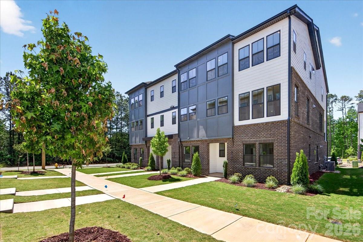 In the heart of Ballantyne, where everyday conveniences, dining, and top-rated schools are just minutes away, a thoughtfully designed end-unit townhome is coming together at Ascend. This Marquis plan is crafted to balance style with flexibility, beginning with a first-floor GenSmart Suite that creates a comfortable space for guests, extended living, or a private retreat. Oak box stairs with metal vertical balusters carry light throughout every level, setting a welcoming tone as you move through the home. At the center of the main living space, the gourmet kitchen is designed to impress with white cabinetry, Golden Gate White quartz countertops, a handcrafted-inspired mosaic tile backsplash, and a GE 36" Gas Cooktop appliance package. A walk-in pantry with upgraded built-in wood shelving keeps everything organized and within reach. Upstairs, the primary suite offers a refined escape with a walk-in shower featuring tiled walls and a tile floor pan, while the secondary bathroom includes tiled walls above the tub for a polished finish. 12015 Elsa Lane brings together thoughtful design and everyday comfort in one of Ballantyne’s most connected locations.