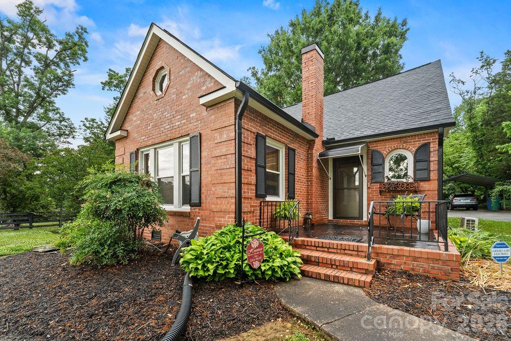 1832 Badin Road is a classic brick home with extraordinary architectural features no longer found in modern construction. The Quion brick corners, arched window, decorative gable window, built in corner cabinets and original hardwood floors make this home a must see.  All the updating has been done and all you have to do is move in.  There is new HVAC, a new roof, updated electrical, new carpet, fresh painted throughout and upgraded appliances.  The home has two living spaces.  The living room has lots of windows and hardwood floors while the den features a stacked stone fireplace and cozy carpet. The dining room and kitchen both have original built in corner cabinets. The kitchen has newly painted sage green cabinets and tongue and groove paneling has been added to many of the ceilings for an Old World feel. The downstairs bathroom and laundry room have been renovated. The bathroom features a large walk-in shower and a soaking tub. The primary bedroom downstairs is spacious with 3 closets.  The upstairs has nice sized bedrooms, a full bath and lots of unfinished storage. The lot is beautifully landscaped and maintained.  The large deck provides a perfect place to enjoy being outside.  The adjacent fenced-in lot is available to be purchased if a buyer desires the extra outside space.  Inside the fence is a walking trail. 
Don't miss the opportunity to purchase this unique property.