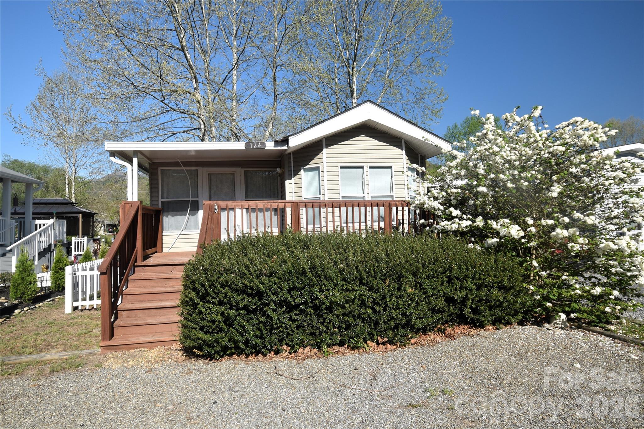 Welcome to Dogwood Lakes.  A community of park model and travel trailers that border the ponds of Dogwood Lakes and Jonathan Creek.  The community has a good mix of full-time and part-time residents. This park model has a 300 square foot side room added with a laundry closet and a large deck in the rear overlooking one of the ponds.  Fish from your backyard.  The park model has a rear primary bedroom with built-ins, a full bath, nice kitchen/dining area and a second small bedroom in the front with a half-bath.  Many of the park models do not have a second bedroom, or the half-bath.  There is also a small, fenced area to the side for Fido.