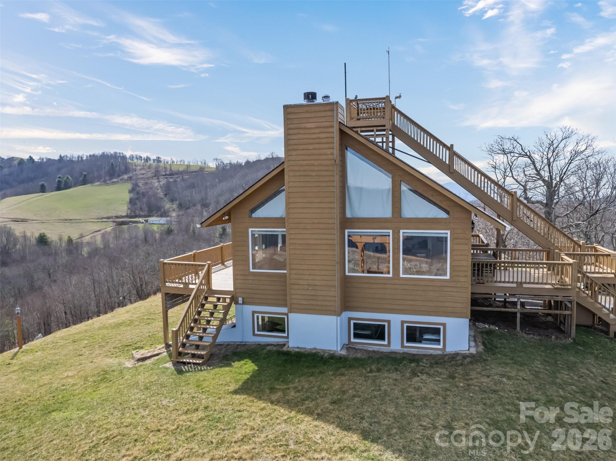 Stunning long-range views in every direction make this 30-acre mountain retreat feel like you’re on top of the world. Indescribable sunrises and sunsets. Mostly cleared and gently rolling, the property offers two additional excellent home sites, providing exceptional flexibility for expansion, guest homes, or investment opportunities. Elevations range from 4,100 to 4,500 feet, delivering cool mountain breezes, peaceful privacy, and abundant wildlife—where hawks soar and nature surrounds you. ***The impeccably maintained main home features recently painted cedar siding and a 2025 roof, blending mountain charm with thoughtful updates. Inside, the main-level living area centers around a dramatic two-story great room with walls of windows, hardwood floors, and a stone-faced wood-burning fireplace. The open kitchen includes an island, breakfast bar, and dining area—perfect for entertaining while enjoying the breathtaking views. The main level also offers two bedrooms, two baths, and laundry, making everyday living convenient and comfortable. ***Step outside onto the wraparound deck or climb to the unique crow’s nest landing for even more spectacular scenery and perfectly private silence. This home truly brings the outdoors in, with views from nearly every room. ***The lower level features a private apartment with both interior and exterior entrances, kitchenette, and Quadra-Fire wood stove, ideal for guests, or multi-generational living. Additional features include: all furniture, a 26-foot-long one-car garage with space for a vehicle and mower, attic access with steps and lighting for extra storage, and propane lines already in place for the range and fireplace, with an owned 500-gallon propane tank. HOA: road maintenance only as needed ($100 in 2025).