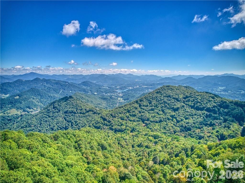 This lot in the Smoky Mountain Retreat at Eagle's Nest offers a beautiful view of Lake Junaluska and the surrounding mountains. Situated within a gated community and surrounded by million-dollar homes, the property features high elevation for cool summers, underground utilities, and paved road access. 

There is a maintenance agreement in place for the shared driveway, the lower portion of which is already paved. Additionally, the location is conveniently situated just fifteen minutes from Laurel Ridge Country Club.
