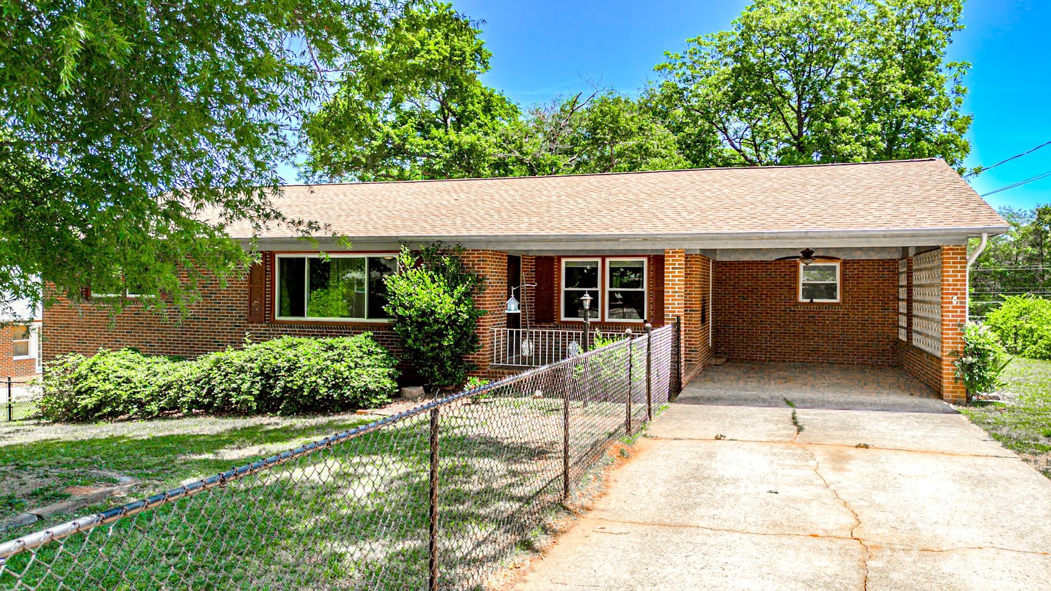 Conveniently located just minutes from downtown Forest City, Highway 74 & 74-A, local restaurants, and shopping, this classic brick ranch offers the perfect blend of a prime location and spacious living.  The main level features a welcoming kitchen with ample cabinetry and counter space, perfect for home-cooked meals and entertaining.  Living area with picture window creates the perfect setting to relax and unwind.  Downstairs, you will find a finished walkout basement with additional space for a recreation room, home office, or in-law quarters.  Enjoy the warm weather from the covered front porch, attached carport, or the fenced front yard. Don't miss out on this fantastic opportunity to own a spacious, solid home in a highly accessible Forest City location!