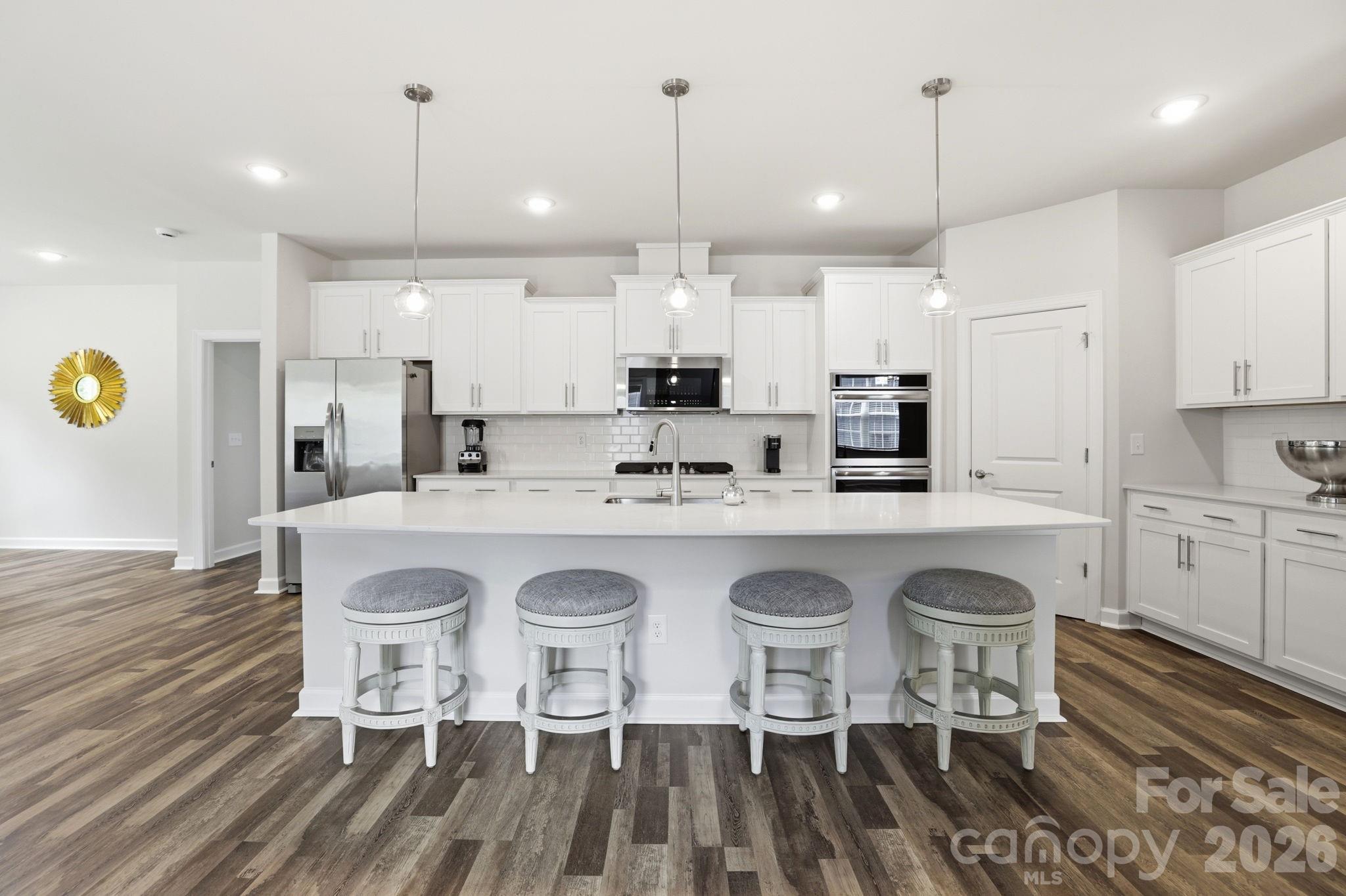 Welcome to 3915 Horsham Street—this nearly new 1.5-story home offers the perfect blend of modern design, flexible living, and high-end finishes, all situated on a premium homesite backing to a private wooded area. Featuring 4 bedrooms and 3.5 baths, this thoughtfully designed home includes a spacious main-level primary suite with dual vanities, walk-in shower, and generous closet, along with two additional bedrooms on the main floor. The open-concept living area showcases a gas fireplace and flows seamlessly into a gourmet kitchen complete with a large quartz island, double ovens, gas cooktop, built-in microwave with exterior venting, and refrigerator included. A private office with French doors, elegant dining room, and convenient main-level laundry with cabinets, sink, and washer/dryer add to the home’s functionality. Upstairs, you'll find a never-lived-in bonus room, private bedroom, full bath, and additional storage—perfect for guests or flex space. Enjoy outdoor living on the screened porch overlooking a flat backyard on over ¼ acre. Additional highlights include a 3-car garage, expansive driveway, abundant storage, and energy-efficient tankless water heater. Ideally located near shopping, dining, and everyday conveniences, this home is move-in ready and better than new! Community clubhouse, pool, pickelball courts, and fitness center currently beig developed. Land behind home will not be developed per Lennar.