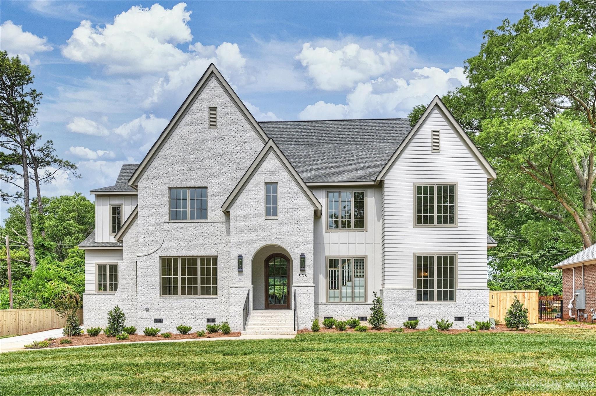 Stunning custom home just completed in Lansdowne! Enter this transitional-style home through the picturesque brick portico & hand-crafted 9’ arched front door. Impressive 2-story foyer w/ large windows bathe the thoughtfully designed, open floor plan home w/ natural light. 10' ceilings, wide-plank hardwoods, & custom millwork testify to the high quality craftmanship! Well-appointed kitchen w/ oversized island, quartz countertops, & adjacent scullery. Dining area boasts coffered ceilings, & inviting living room showcases custom built-ins, a cozy fireplace, & sliding glass doors connecting to a covered walkout patio w/ fireplace. Retreat to the main level primary suite w/ floating tub & expansive walk-in closet. Add'l guest suite/office on main. Upper level presents 4 add'l BR's w/ ensuite baths & walk-in closets, large bonus room & flex space. Detached 2-car garage. Fenced, flat .55 acre lot in walking distance to PDS & 10-min drive to Southpark, Cotswold, the Arboretum, or Matthews.