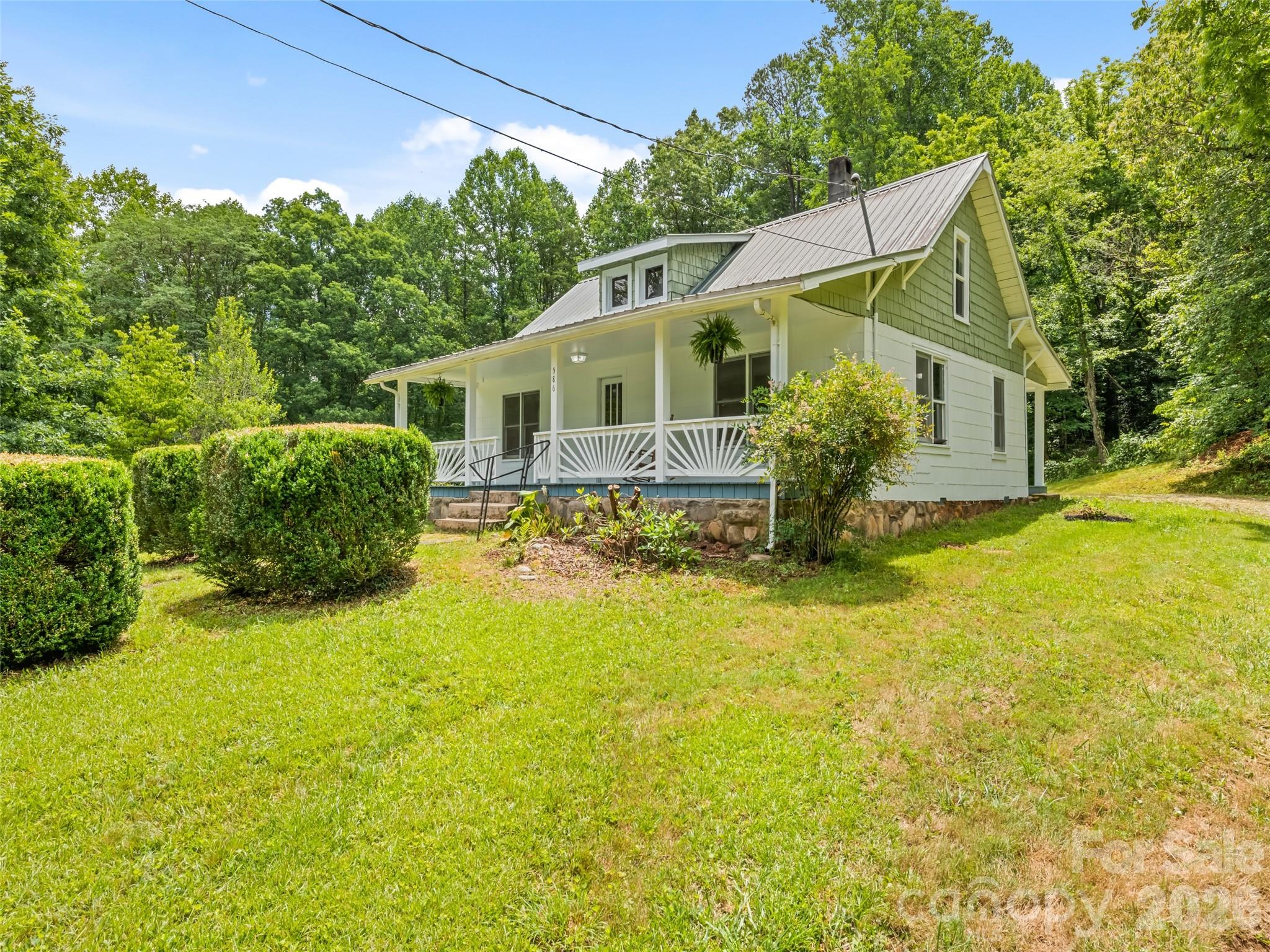 This small, quaint white farmhouse, originally built in 1936, offers the perfect opportunity to embrace
pastoral mountain rural living. The 1.5-story home features three bedrooms and 1.5 baths, sitting
beautifully on a lovely, rolling, cleared green space that is framed by a private wooded area. While the
exterior has been freshly cleaned & newly painted, the interior awaits your design imagination to bring it
to life with modern updates and classic farmhouse décor. The home boasts incredible outdoor living spaces,
including a full front porch with plenty of room for rockers and an old-fashioned porch swing, as well as
a private full back porch that is ideal for restful evening suppers or quiet relaxation. Additionally, the
grounds are completely ready for your own custom relandscaping to create private entertaining areas, and
the versatile second-floor space can easily be transformed into guest sleeping quarters, an entertainment
hub, or a private workspace.
Easy access without the hassle of a long mountain driveway. It is perfectly suited to become a year-round permanent home, a weekend vacation getaway, or a lucrative vacation rental. Best of all, you are located just minutes away from major regional attractions, including The Great Smoky Mountain National Park, the Blue Ridge Parkway, Cherokee, Bryson City, Sylva, and Harrah’s Casino.