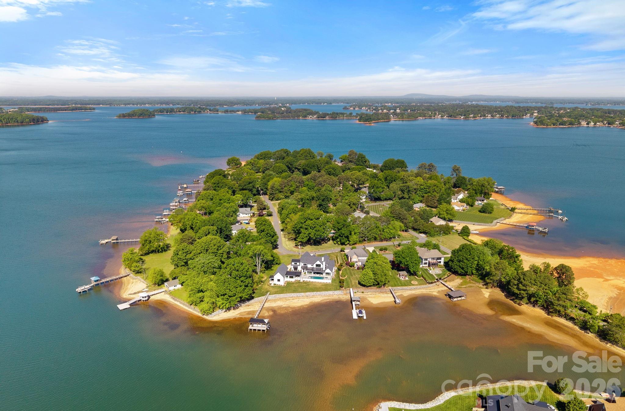 Completed in 2024 by renowned builder Patrick Joseph, this masterfully crafted waterfront estate represents the pinnacle of luxury and modern engineering. From the moment you approach the front porch—adorned with Blue Ice stone from Oakville National Stone and solid maple double doors—the home’s superior build quality is evident. The exterior features premium low-sheen paint and a state-of-the-art electronic encapsulated screen system with integrated speakers and Ring security.
Inside, the home unfolds over 6–7” engineered hardwood floors, with 11-foot ceilings and rustic wood beams adding architectural depth to the living spaces. The chef’s kitchen is a culinary masterpiece, centered around a 2.5-inch thick quartz island and professional-grade appliances, including double Wolf ovens, a Wolf gas cooktop with a pot-filler, a Cove dishwasher, and a Sub-Zero double refrigerator. A unique, restaurant-sized pizza oven is fluted through the roof, while a massive walk-in scullery provides a Sub-Zero freezer, warming drawer, and abundant cabinetry. The main level also features a high-tech study with "Clarissa" electric blinds and a versatile powder room with a hidden door leading to a massive laundry and storage area that connects directly to the primary suite.
The primary wing is a private sanctuary offering direct sliding door access to the pool and a spa-like ensuite. The bathroom features his-and-hers vanities with integrated lighting, a separate soaking tub under a chandelier, and a walk-in rainhead shower with triple sprayers. Upstairs, accessible via an extra-wide staircase with iron balusters or the private elevator, you’ll find a sophisticated loft reading area and a step-up theater room. This cinema space is professionally sound-engineered, featuring Marantz and Sony equipment, a 150” screen, and keypad-controlled subwoofers. Each guest bedroom serves as an ensuite retreat, including a lakeside room with tongue-and-groove walls and a towel warmer. Unique to this estate is a climate-controlled hydroponic bonus room with waterproof flooring, ideal for year-round cultivation.
The outdoor living space is an entertainer's dream, anchored by a heated saltwater pool and spa with AquaLink multi-colored lighting and Bluestone pavers. The waterfront pool house is a secondary residence in itself, featuring a full kitchen with handmade stone countertops and a massive 14-foot RV garage with epoxy floors. Boaters will appreciate the custom 13,500-lb boat lift and the Trex pier equipped with built-in lighting and electricity.
Every technical detail has been considered for maximum comfort and peace of mind: a full-home Generac generator, an encapsulated crawl space with a dehumidifier, four thermostat controllers, and an extra-wide three-car garage with dual 220V electric vehicle outlets. This is more than a home; it is a fully automated, high-performance retreat designed for the most discerning homeowner.