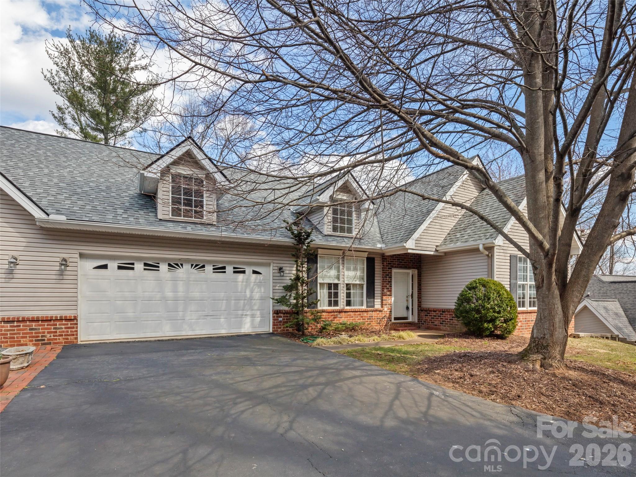 Welcome to Sought--After, spacioous, low maintenance, convenient gated South Asheville living! This sunlit end unit townhome offers gracious one-level living on main floor ;with vaulted ceilings, and great guest, or larger family, accomodations on the lower level. Kitchen, Laundry, Dining area, and open keeping area with gas log fireplace all on main level. Five bedrooms and four full baths (three ensuite) all together with warm roomy gatheriing spaces on each level. 2-car garage adjacent to kitchen and pantry for easy unloading. Step outside through glass doors from each level to large decks with seasonal views. So close to shopping, dining, healthcare, schools, sports and exercise venues, major highways, and eclectic Downtown Asheville. Exterior maintenance and landscaping included in HOA for true :Lock and Leave" convenience. Visit southsidevillageasheville.com