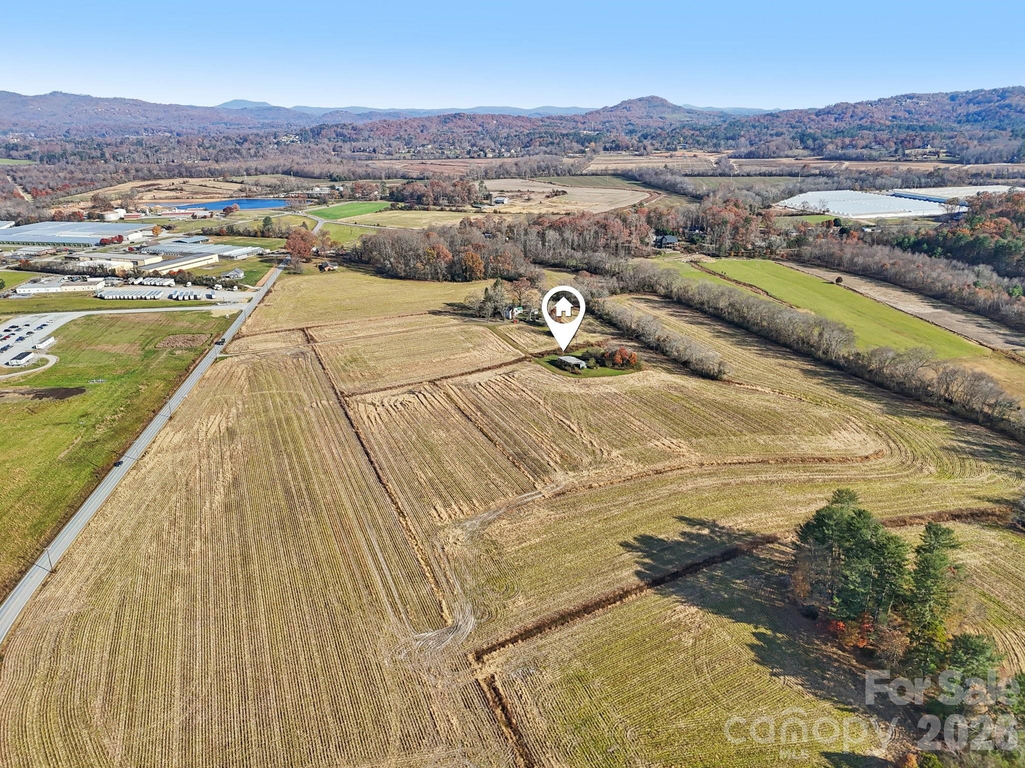 Presenting an exceptional 63-acre commercial development opportunity in the heart of Mills River, North Carolina. One of Western North Carolina’s fastest-growing and most strategically positioned commercial and industrial markets. Located at 32 School House Road, this expansive tract offers a unique combination of scale, zoning versatility, access to public utilities, and proximity to major regional transportation assets. Zoned MR-NC (Neighborhood Commercial), the property supports a wide array of commercial, service-oriented, and mixed-use development possibilities, with the potential for rezoning or conditional approvals for larger commercial or industrial concepts. This flexibility makes the site highly attractive for investors, developers, and end-users seeking a significant presence in a market experiencing sustained industrial and commercial demand.

A key feature that sets this property apart is the availability of public water and sewer located adjacent to the tract—a rarity in Mills River, where many large parcels lack utility access. The presence of municipal utilities greatly enhances the development potential and substantially reduces upfront infrastructure costs. The land itself is primarily flat and usable, offering broad, functional acreage suitable for commercial campuses, retail and service centers, flex-industrial development, warehousing, light manufacturing, logistics, research facilities, or mixed-use clusters, subject to Town of Mills River requirements and approvals. The site’s layout and topography provide numerous options for phased development, subdivision, or a single large-scale commercial project.

Mills River has emerged as a powerhouse for industrial and commercial activity due to its central location between Asheville, Hendersonville, and Brevard, as well as its immediate proximity to Interstate 26, U.S. 280, and the Asheville Regional Airport. National and international companies—including Sierra Nevada Brewing, Amazon, FedEx, Pepsi, GF Linamar, and others have invested heavily in this corridor, drawn by excellent transportation access, a stable workforce, logistics advantages, and a pro-business regulatory environment. Industrial and commercial land absorption in Mills River has outpaced supply for years, creating strong long-term value and making large contiguous tracts with utility access increasingly scarce.

An old 1850’s colonial home remains on the property; however, it is considered to have no contributory value and is not expected to affect redevelopment plans. The highest and best use of the site lies overwhelmingly in its commercial and industrial potential. With its combination of location, visibility, access, utilities, and sheer acreage, this property represents one of the most compelling development opportunities currently available in Western North Carolina.

Whether your vision is a corporate campus, industrial park, commercial center, or an investment hold for future appreciation, 32 School House Road delivers the fundamentals that developers and end-users seek—location strength, infrastructure, zoning flexibility, and market momentum. This is a rare chance to control a legacy-sized tract in a thriving commercial hub poised for continued long-term growth.