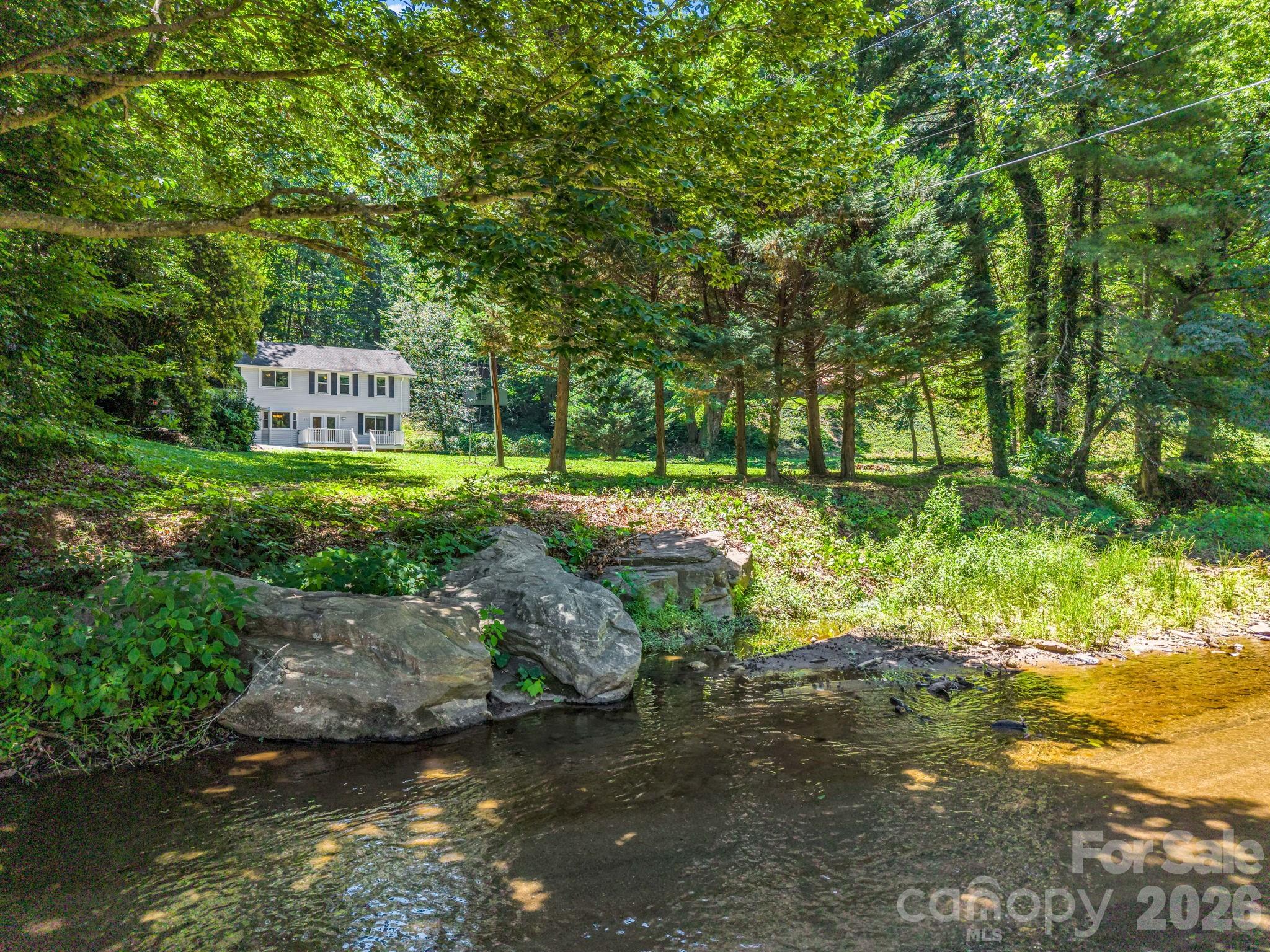 Wake up to mountain views, relax to the sounds of the North Pacolet River, and enjoy the privacy of 1.43 level acres just minutes from downtown Tryon. This updated 3-bedroom, 2-bath home offers approximately 1,664 heated square feet with a unique inverted floor plan designed to take advantage of its beautiful natural setting.

The upper level features three bedrooms, a full bath, and a convenient laundry/mudroom. The primary bedroom includes a sitting area and a private deck. The main living level offers a spacious living room, dining area, office nook, full bath, and a newly renovated kitchen with abundant cabinet space. Step onto the composite front deck to take in mountain and river views and enjoy the peaceful sounds of the Pacolet River. The main living level has undergone extensive renovation, including updated wiring, drywall, kitchen, bath, flooring, carpet, fixtures, and water heater, creating a comfortable and inviting space while preserving the home's character. Two ductless mini-split heat pumps, one serving the main living area and one in the primary bedroom, provide efficient year-round comfort. All kitchen appliances, washer, and dryer are included, making this home move-in ready.

Large windows fill the home with natural light and frame views of the surrounding landscape. Outside, the level yard offers plenty of space for gardening, pets, recreation, or simply enjoying the outdoors. A detached storage building provides additional room for hobbies, tools, and equipment.

Conveniently located near Tryon, Columbus, Landrum, area equestrian venues, hiking trails, wineries, breweries, shopping, and dining, this riverfront property offers a rare opportunity to enjoy the beauty of the Carolina foothills in a peaceful and accessible setting. Whether you're looking for a full-time residence, mountain getaway, or investment property, this home delivers an exceptional combination of updates, views, and natural beauty.