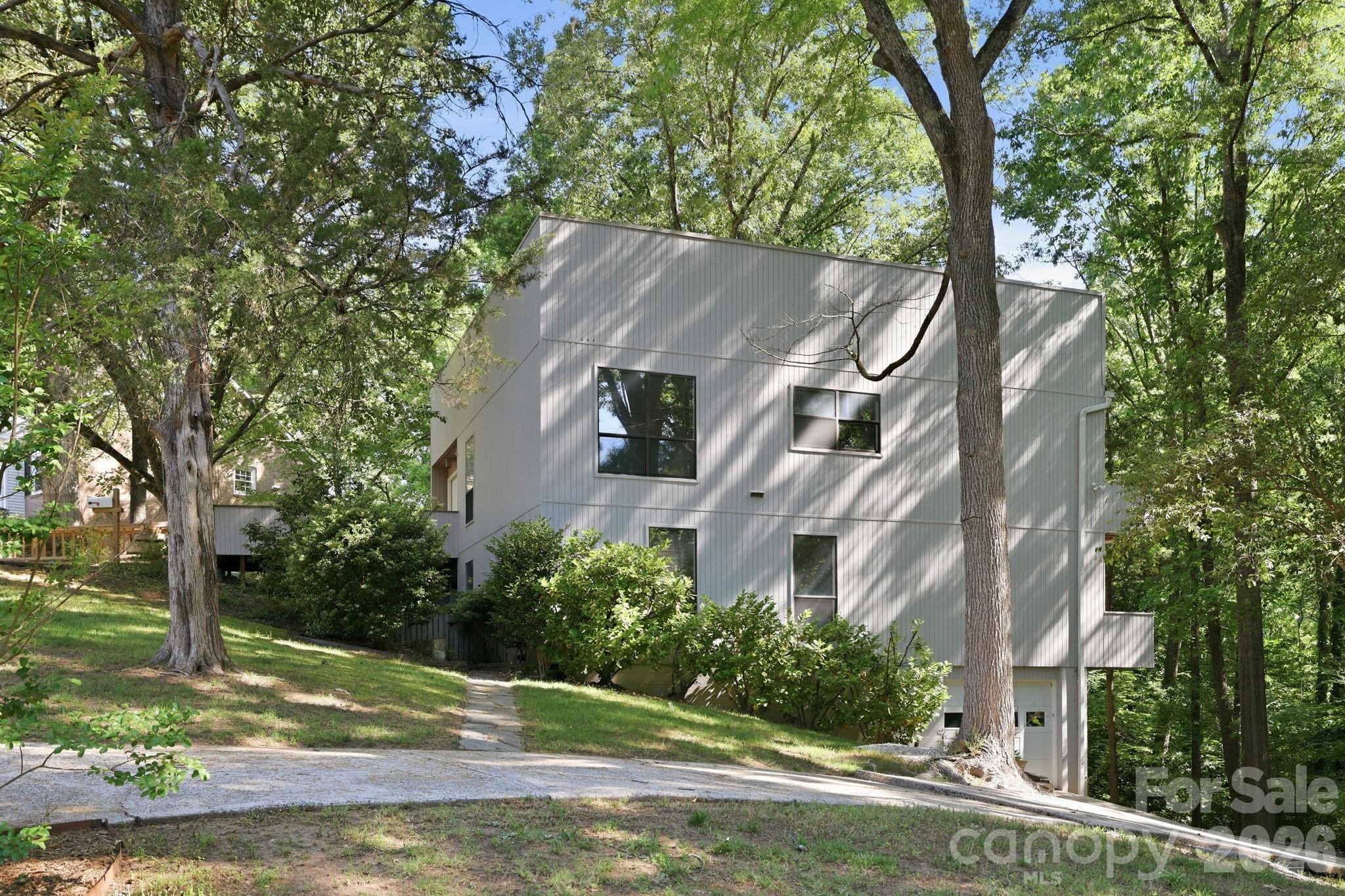 Nestled on a private, tree-lined one-acre lot in Mountainbrook, one of SouthPark/South Charlotte’s most established and sought-after neighborhoods, 3423 Tinkerbell Lane offers a rare blend of privacy, character, and convenience.

Built in 1977 with bold contemporary architecture, this distinctive home feels like a peaceful treehouse retreat surrounded by mature trees. The setting offers a true sense of escape, while still being just minutes from SouthPark’s shopping, dining, everyday conveniences, and many of Charlotte’s top public and private schools.

With approximately 2,900 square feet and 4 bedrooms, the home features a unique tiered layout designed to capture natural light and wooded views. The main living areas are positioned on the upper level, creating an inviting space for gathering, entertaining, and enjoying the serene surroundings. Architectural details such as wide banisters, angled walls, multiple balconies, and generous windows add warmth, interest, and personality throughout the home.

The large gathering room with a standalone fireplace provides a comfortable space for entertaining or relaxing evenings at home, while the cozy den is ideal for movie nights or quiet downtime. The primary suite offers peaceful views through the trees, and the lower level creates the feel of a private retreat with walk-out access to the lower-level deck, affectionately known as “Our Secret Garden.” This secluded outdoor space offers a peaceful escape for quiet reflection, morning coffee, or outdoor entertaining, all surrounded by the natural beauty of the wooded lot. The lower level feature a tandem garage that will hold 2 cars. 

Lovingly maintained for more than three decades, this home offers the opportunity to move in and enjoy its unique character or thoughtfully renovate over time to make it your own. The one-acre wooded lot provides exceptional privacy, mature landscaping, and a beautiful natural setting, while still being part of a vibrant and welcoming community.

Residents of Mountainbrook also have the option to join the Mountainbrook Swim and Tennis Club, offering community amenities without a mandatory HOA. Known for its mature trees, welcoming atmosphere, and strong sense of community, Mountainbrook continues to be one of Charlotte’s most desirable neighborhoods.

3423 Tinkerbell Lane is more than just a home—it is a special opportunity to enjoy space, privacy, and character in an exceptional SouthPark location.