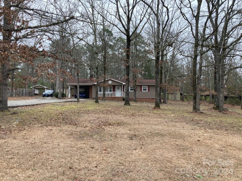 Check out this adorable home on an acre of land.  The open floor plan is great for entertaining or just relaxing. The Living Rooms wood burning fireplace is perfect to enjoy the chilly days and nights. An amazing large covered patio area for outside entertaining.  A carport and several sheds in back for additional storage.  You will Love the circular driveway behind the home for easy entrance and exiting.  Home is being sold AS IS.