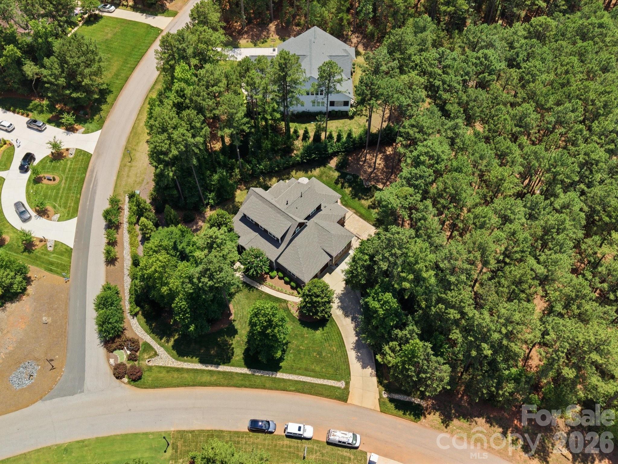 If you’ve been waiting for privacy, views, and convenience all in one—this is it. Located in desirable Riverchase Estates, this Craftsman-style home is surrounded by peaceful woods, offering stunning views from every level. Natural light pours in through expansive windows, highlighting beautiful details like tray ceilings, designer lighting, and custom built-ins. Enjoy the feeling of a secluded retreat while staying just minutes from Ballantyne, Indian Land, and major commuter routes. A dedicated office provides the ideal work-from-home space. The gourmet kitchen is a true standout, featuring top-of-the-line stainless steel appliances, a large center island, gas range, and a pantry with custom shelving and lighting, all seamlessly connected to a functional open floor plan ideal for everyday living and entertaining. The main-level primary suite provides comfort and privacy, creating a true retreat within the home. Stacking sliding doors open to a covered back porch with a fireplace and outdoor kitchen, creating exceptional indoor-outdoor living. An extended paver patio offers additional space to relax or entertain while enjoying the serene backdrop, and a backyard storage shed adds convenience. A fully finished 2-car garage features upgraded rubberized flooring for a clean, modern look. A new roof was installed in 2025. Residents of Riverchase Estates enjoy exceptional amenities including a gated entrance, clubhouse, outdoor pool, tennis courts and more. Ideally located, this home offers the perfect balance of tranquility and accessibility, just minutes from Ballantyne, Indian Land, and interstate access. Schedule a showing today!