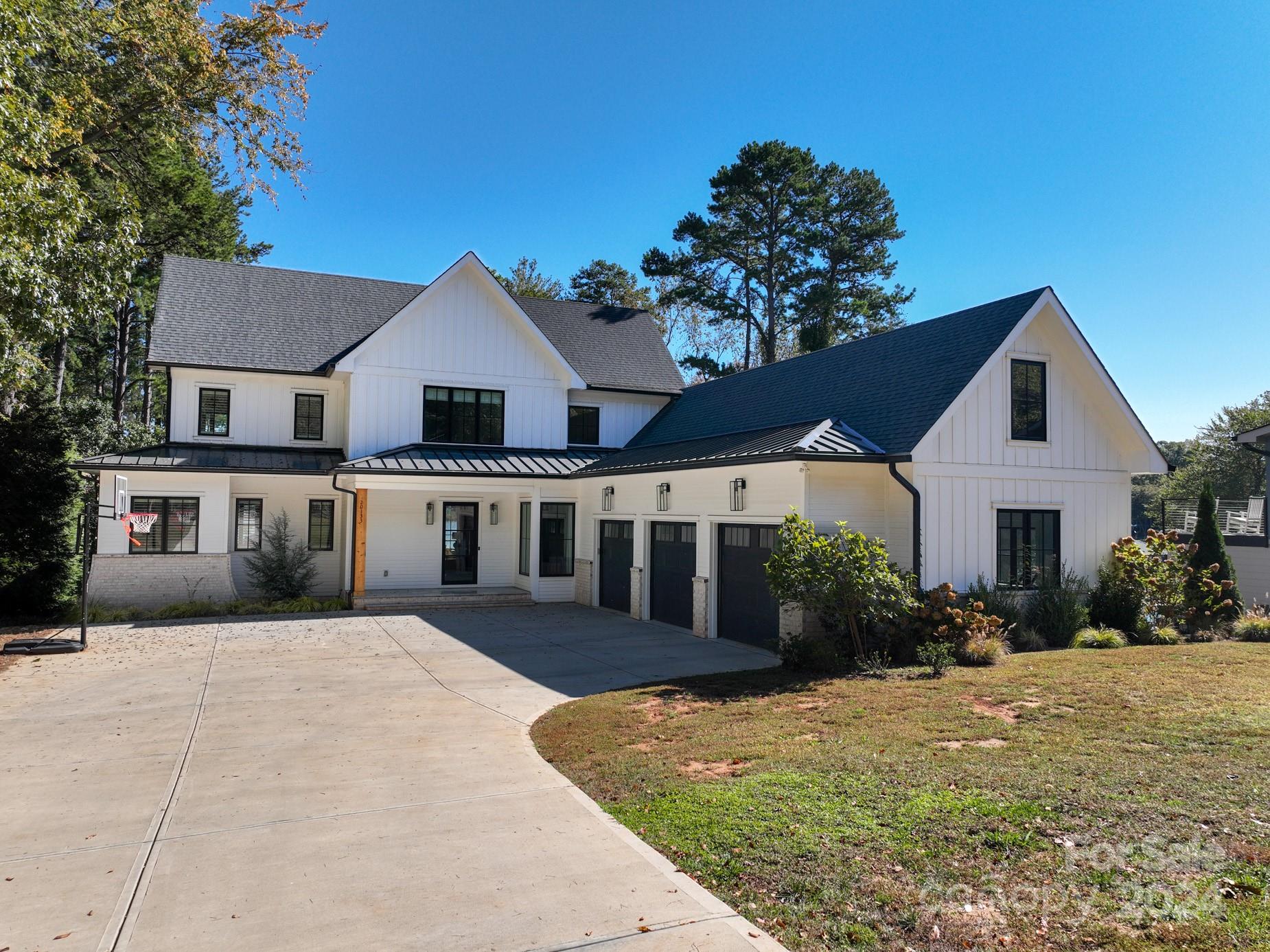 Stunning, custom built Lakehouse in sought after Cornelius! Constructed in 2021, this modern farmhouse style home on Lake Norman features open floor plan with designer finishes throughout and water views from nearly every room. Enjoy cooking in your spacious chef's kitchen with Thermador appliances, quartz countertops and huge island. Butlers pantry/skullery is perfect for entertaining. Take in your lake view while you relax on your oversized screen porch with woodburning fireplace and outdoor heaters for those cool fall evenings. 4 bedrooms, with primary bedroom on the main level. 3 bedrooms upstairs with a large loft space. Enjoy the lake with no commute after working in your beautiful home office. Enjoy private covered boat dock with boat lift. Drive the boat to dinner at one of Lake Norman's waterfront restaurants.  All furnishings for sale, so you can move right in!