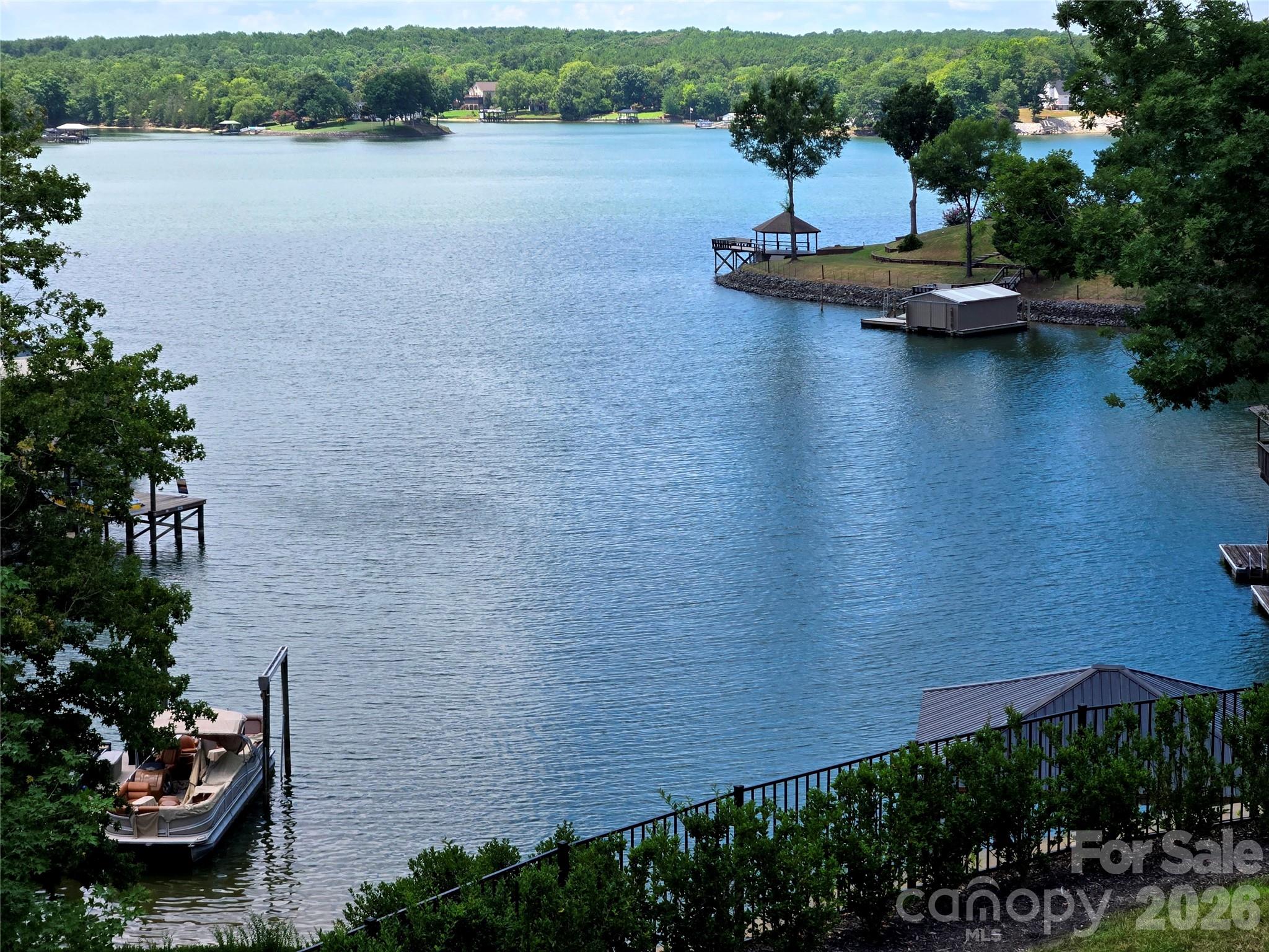 This is an absolutely stunning 6000 sq. ft. new construction home offering everything you would want when in a waterfront oasis. With a premiere location on the Charlotte city side of Lake Wylie this home offers captivating views throughout with beamed and soaring cathedral ceilings and palladium windows to take one's breath away. A fabulous gourmet kitchen has a 60" refrigerator/freezer, 48" Pro series range, gorgeous quartz tops complimented by a fully equipped second chef's prep kitchen for special gatherings and parties. A finished basement offers a 5th bedroom/bathroom, plus a full pool bath, huge rec. room, wet bar and large patio doors opening to a 40 ft. pool and spa set off by the marble patio. Large terraced main level lawns lead to a natural gently slopped stone walkway  to the waterfront and boat dock. The nearby Palisades Country Club offers Golf and Tennis memberships for additional recreational activities and access to the city amenities is a breeze.