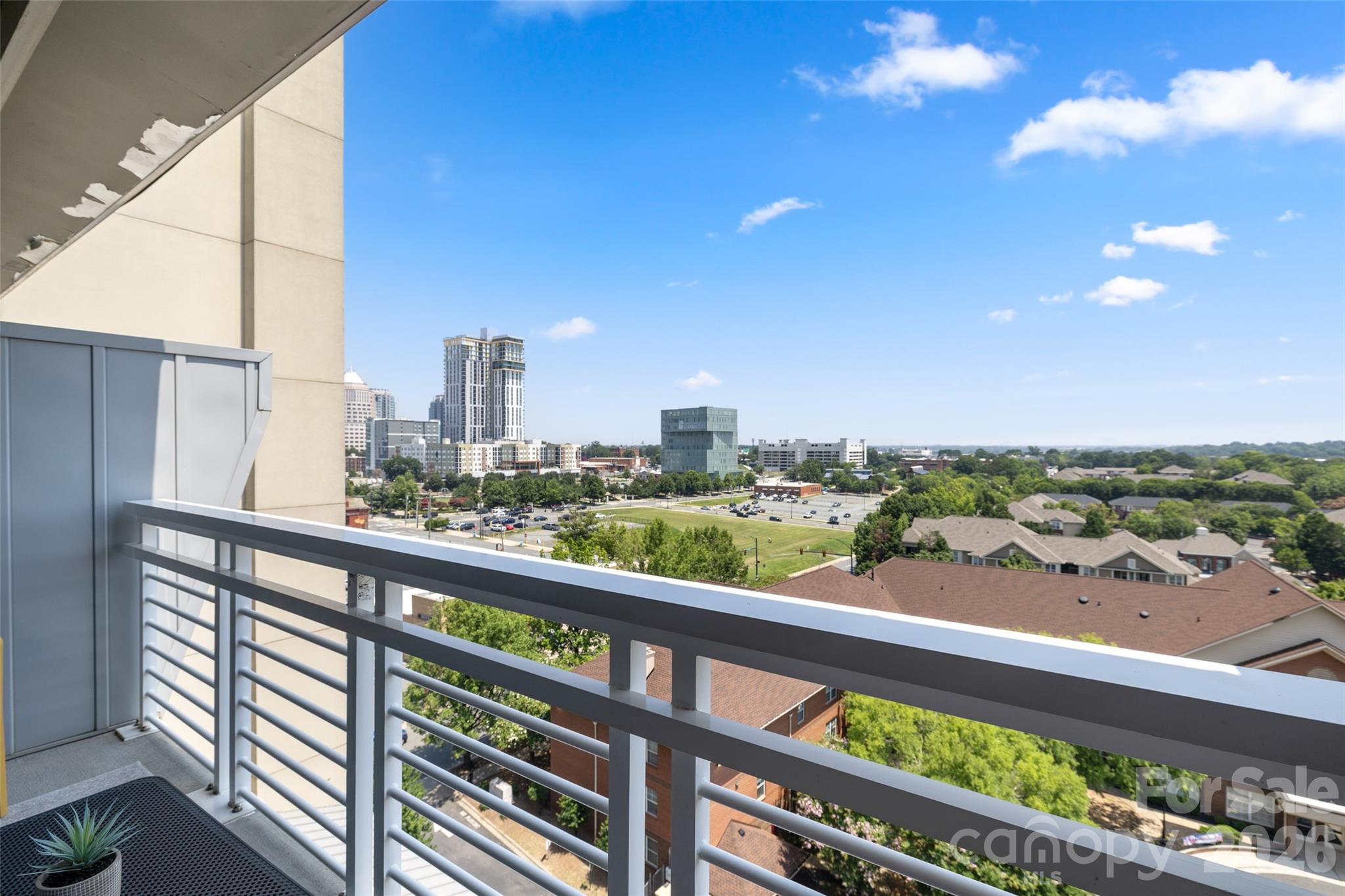 Enjoy modern urban living in the heart of Uptown Charlotte from this 9th floor condo featuring an open floor plan, industrial style details, and a private balcony with impressive views. Floor to ceiling windows fill the living and dining areas with natural light, while exposed concrete ceilings and ductwork add distinctive loft style character. The kitchen features white cabinetry, granite countertops, tile backsplash, stainless steel appliances, and generous cabinet space. The bedroom offers an adjoining full bath with a tiled shower and ample storage. Step outside to the private balcony and enjoy sweeping views overlooking the surrounding neighborhood and Uptown skyline. Located in First Ward with convenient access to the light rail, restaurants, parks, shopping, and all that Uptown Charlotte has to offer. Building amenities include an 18th floor rooftop terrace with panoramic city views. Owner financing is available.