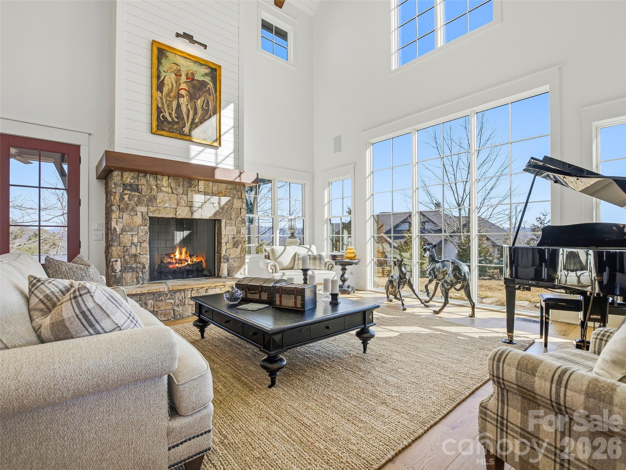 Seller is offering an attractive Buyer Personalization Incentive with an acceptable offer, creating a rare opportunity to make this exceptional mountain-modern residence uniquely your own — Rarely does a setting like this become available this close to downtown Asheville. Perched high along Falcon Ridge's signature ridgeline within an exclusive enclave of just 28 homes, this custom-built mountain modern retreat captures the kind of long-range Blue Ridge views, privacy, natural light, and a usable flat lot buyers come to the mountains hoping to find—yet often can't — True to the principles of modern mountain architecture, the exterior is intentionally understated, allowing the dramatic interior spaces and panoramic views to take center stage. Once inside, soaring vaulted ceilings, striking exposed beams, and expansive walls of glass fill the home with natural light while framing mountain views from nearly every major living space — Even more remarkable, it delivers all of this just minutes from Whole Foods, Trader Joe's, acclaimed restaurants, galleries, live music, and endless hiking trails—placing the very best of Asheville within easy reach — The open-concept design centers around a stunning great room and chef's kitchen with high-end appliances, custom cabinetry, and refined modern finishes throughout. The main-level primary suite offers comfort and ease for everyday living, while the upper level features two well-separated guest ensuites, a private office, and a remarkably spacious bonus room—ideal as a family room, media room, art studio, fitness space, or flexible retreat for family and guests — In addition, Seller will provide a $50,000 Buyer Personalization Credit with an acceptable offer, allowing the next owner to tailor select features to their own tastes and lifestyle. Whether envisioning updated lighting, custom window treatments, enhanced storage solutions, select finish upgrades, landscaping enhancements, or other personal touches, this $50,000 credit allows buyers to make an already exceptional home uniquely their own — Covered outdoor living, fireplace, and fire pit were all designed to maximize the panoramic year-round backdrop. No remaining homesites can obstruct the views, and the home's position at the highest point in the community further enhances the sense of privacy, openness, and natural light — At just two years old and presenting in like-new condition, this home offers a rare combination of newer construction with a home warranty, architectural character, protected views, and close proximity to downtown Asheville — Elevator installation capable, with quote available upon request — A detailed features list and floor plans are included in the photo gallery.