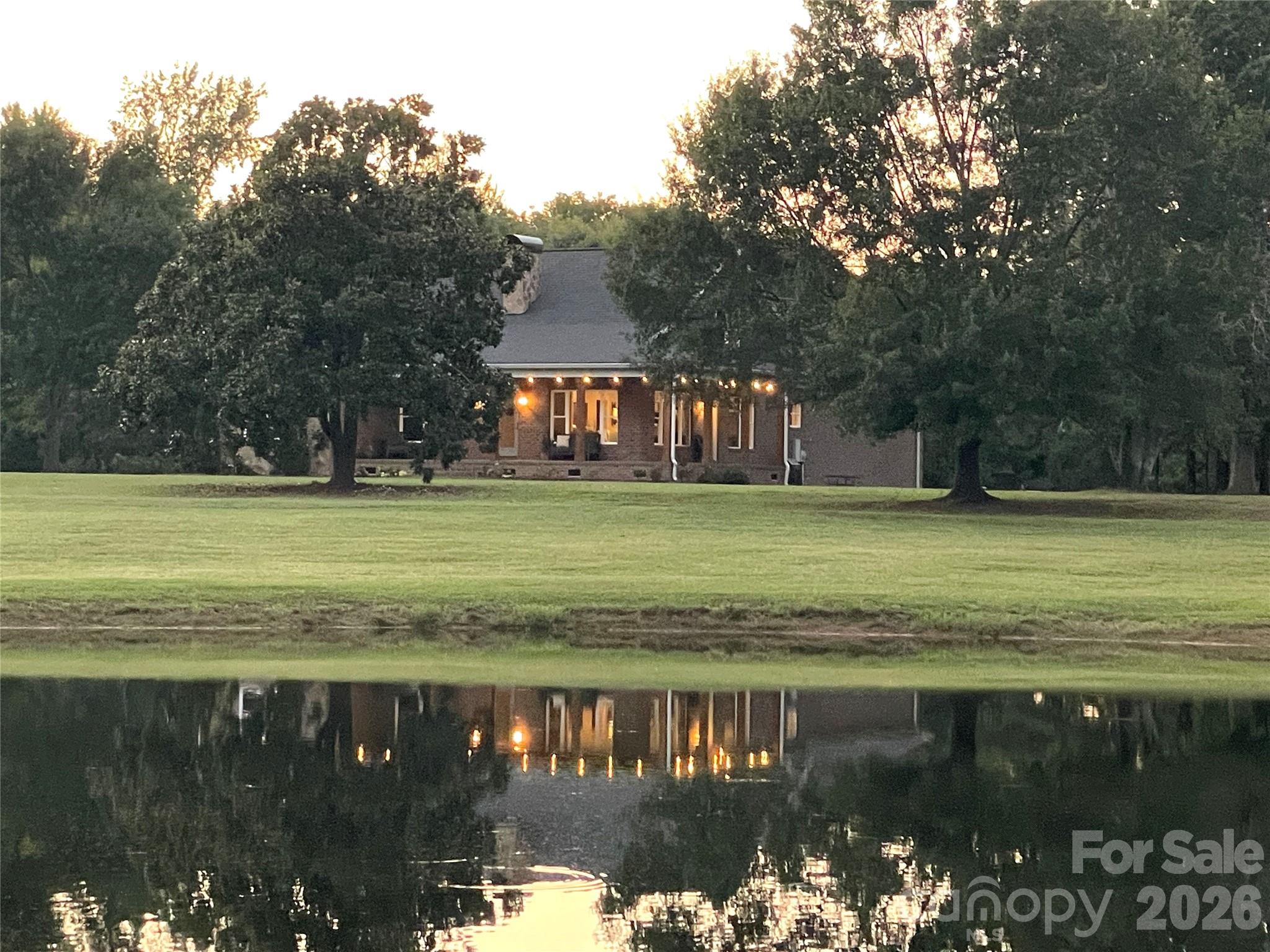 Make your dreams a reality with this slice of paradise. Imagine early mornings on the wrap-around porch overlooking majestic magnolia trees and the morning mist rising off the pond, or sunset evenings gathered around the fire enjoying smores, all while being transfixed by the fun & tranquility of watching your fishing bobber jump from the bass in your stocked 3/4 acre pond. Set on 7.5 picturesque acres with breathtaking views of the stocked pond and mature landscaping, this custom estate offers the perfect blend of southern charm, comfort, and privacy. Designed for peaceful living and effortless entertaining, the property offers many options whether you want chickens, gardens, or a place for running and playing there's room for it all. The home features an open-concept floor plan, extensive upgrades throughout, and a welcoming wraparound covered porch perfect for enjoying the serene surroundings with your morning coffee or evening beverage. The updated chef’s kitchen creates a beautiful setting for everyday living and gatherings. A firepit by the pond is the perfect way to end a busy day or entertain friends and family. Nearly every room in the home captures stunning views of the property, including the spacious primary suite, where you can wake up to peaceful scenery and abundant wildlife right outside your window. Thoughtful upgrades include a newly added second story with a bonus room and office, HVAC system and crawl space ductwork, tankless water heater, dishwasher, washer and dryer, kitchen countertops, custom wood shelving in closets, mudroom built-ins, recessed lighting, a dedicated gas line for grilling, a sealed crawl space and much more. An oversized garage provides ample space for weekend toys, hobbies, or additional storage. See attached feature sheet for a complete list of upgrades. The home sits on almost 6.2 acres. An additional 1.4 acre lot is included (Lot D) which is separated out from the 7.5 acres so you can build another home as immediate equity or build for parents, kids, etc..  All this within a quaint town and the sought-after Buford schools.