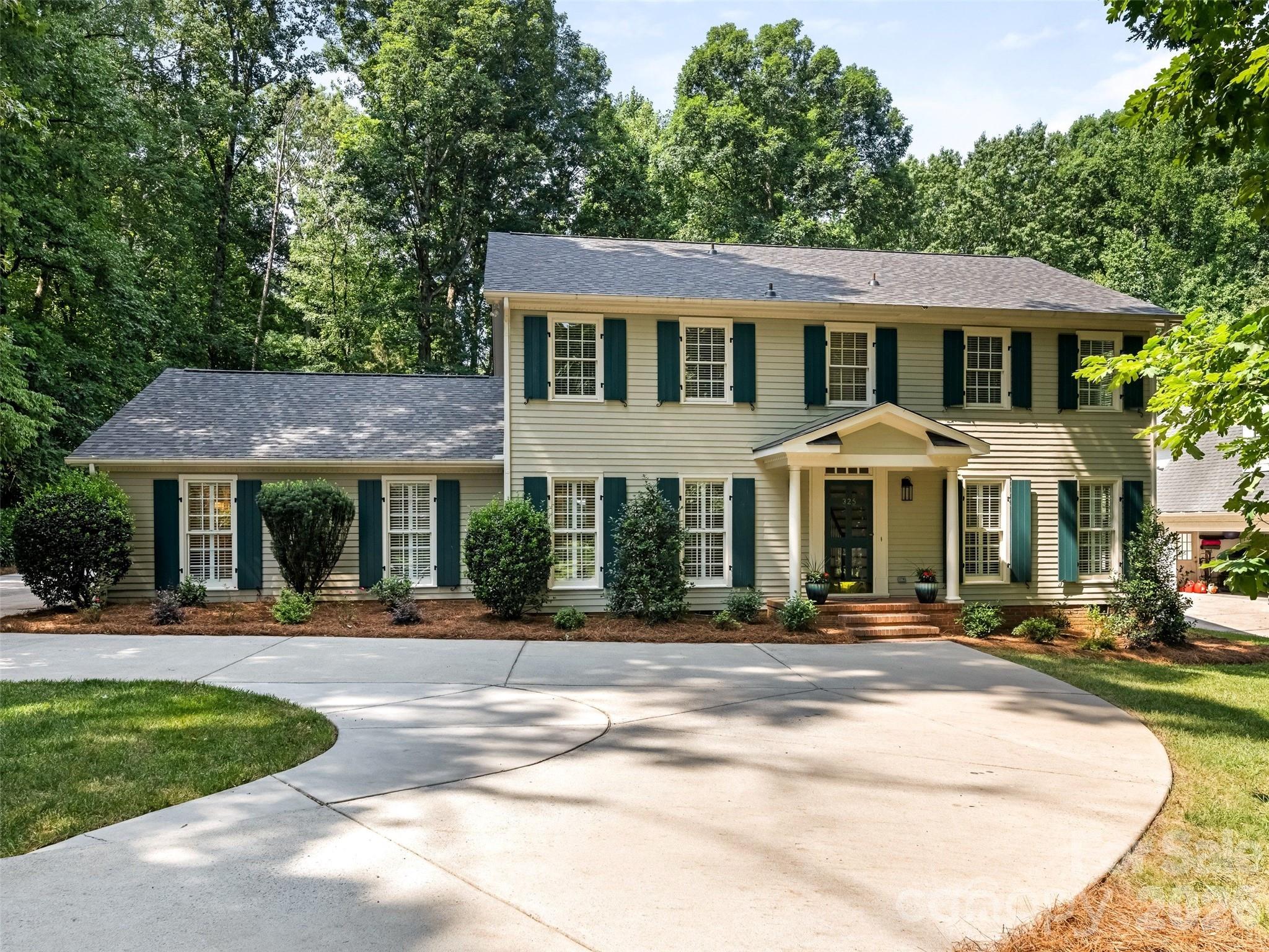 WELCOME HOME - YOU CAN HAVE IT ALL! Lovingly Maintained and Updated Traditional Home on Beautiful Private Wooded (.94 Acre) Lot  Featuring Screen Porch w/EZ Breeze Windows that Opens to Custom Patio w/Trellis, Fire-Pit and Lush Mature Landscaping - Quiet Retreat! Conveniently Located to Matthews & Arboretum w/Excellent Shopping/Restaurants and Top Rated Public and Private Schools. Attached Two Car Garage w/Large Storage Room, Detached Oversized Carport and Detached Garage/Workshop. Gracious Foyer w/Brick Flooring, Living Room Opens to Family Room w/Built-in Bookcases and Fireplace w/Raised Hearth. Spacious Updated Kitchen/Breakfast Room Featuring White Cabinetry, Granite Countertops, Center Island w/Breakfast Bar, New Stainless Steel Gas Cooktop, Double Ovens & Microwave - Breakfast Room Overlooks Patio and Wooded Setting. Two Primary Bedroom Suites - Main Level Suite Features Fireplace, Bath w/Double Vanity, Tub and Shower, New Lighting and Mirrors - Upstairs Primary Bedroom w/Vanity and Updated Shower. Upstairs Features 3 Additional Spacious Bedrooms and Full Bath w/Double Vanity and Tub/Shower Combination. Plantation Shutters, Freshly Painted Interior (Alabaster Color/Sherwin Williams), Refinished Wood Flooring, New Carpet, Updated Lighting & New Roof (2026). Truly Move-In Ready - Don't Miss This Very Special Home!
