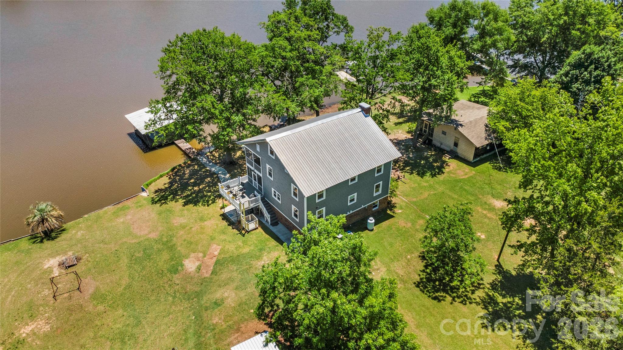 Start living the lake life in this fabulous 6 bedroom, 3.5 bathroom home with covered double boat slip plus a boat ramp on Lake Wateree! This house boasts three levels of living plus a walkout basement, an outside elevator lift, outdoor spaces and much more. The main floor offers the primary bedroom, full bath, kitchen with breakfast island and dining area. Huge living room with brick fireplace. Second floor offers four bedrooms and full bath plus full length covered back deck. Third floor is an enormous bedroom with half bath. Huge screened-in back deck runs entire back of main floor and leads to another outdoor deck, both perfect for relaxing and entertaining while enjoying a view of the lake and your private floating dock. Walkout lower level offers a working kitchen and a full bath with shower, plus the huge covered patio, all very convenient for hosting guests. Recent upgrades include vinyl siding, well pump replacement and new septic system. With vinyl windows and a metal roof, this home is low maintenance and ready for you to enjoy the water; whether swimming, kayaking, boating, or fishing Don’t let this one slip away!