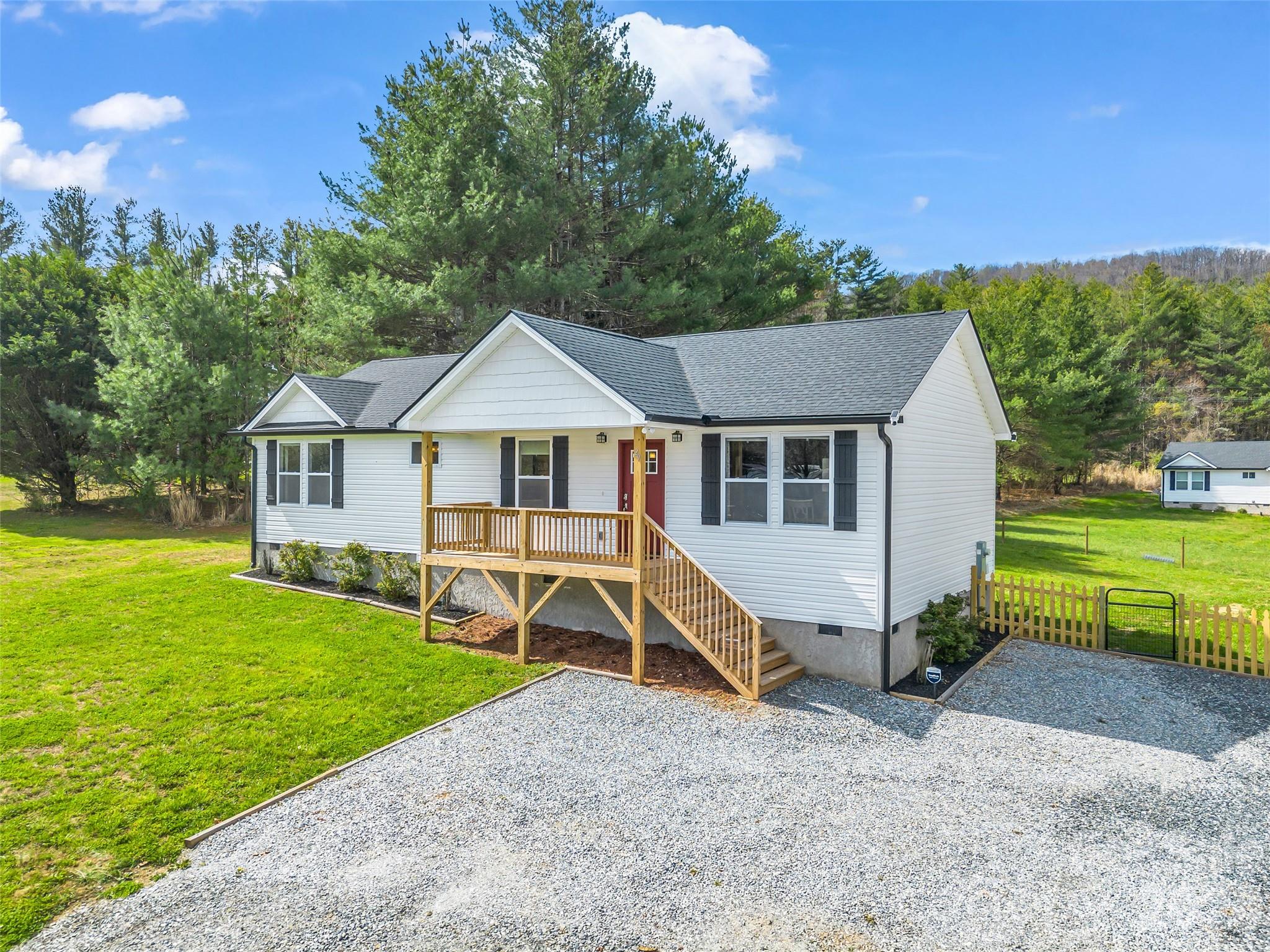 There’s something refreshing about a home that simply feels right from the moment you arrive. Set on a sunny three quarter-acre with room to breathe, this newly built home offers that rare balance of open, airy spaces designed for everyday living, paired with just enough separation to make it feel settled and comfortable. A private driveway welcomes you home, while an additional shared drive offers flexibility for guests or easy access, a subtle convenience that can make daily life just a little easier. Mornings begin on the covered front porch, coffee in hand, while afternoons drift easily from the light-filled living space to the back deck and fenced yard. Inside, the flow is effortless with an open living, dining, and kitchen area that feels connected yet uncluttered, with natural light pouring in and a layout that just makes sense. Down the hall, bedrooms are thoughtfully tucked away, creating a quiet retreat at the end of the day. Perfectly positioned between Hendersonville and Brevard, you’re never far from hiking trails, waterfalls, and everything that makes this area so special, yet always glad to come home. Move-in ready, easy to love, and designed for the way you actually live.