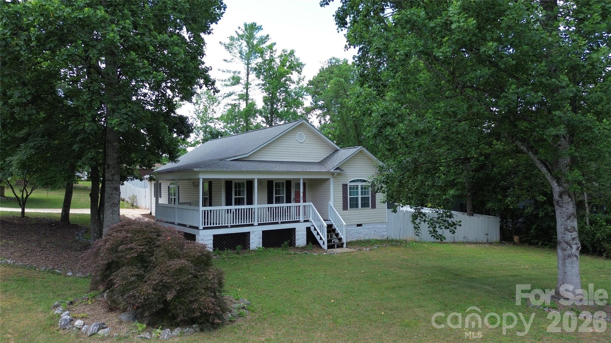 Conveniently located just minutes from Lake Rhodhiss, downtown Granite Falls, schools, parks, shopping, and dining, this 3-bedroom, 2-bath home offers comfortable one-level living with an open floor plan and vaulted ceilings. The kitchen features updated countertops, tile backsplash, a pantry, and includes appliances. The split-bedroom layout provides privacy for the primary suite with an en-suite bath and dual closets. Enjoy the wraparound covered porch, back deck, fenced backyard with fire pit, attached two-car garage, attic storage, and two outbuildings for additional storage. A great opportunity to make this home your own!
