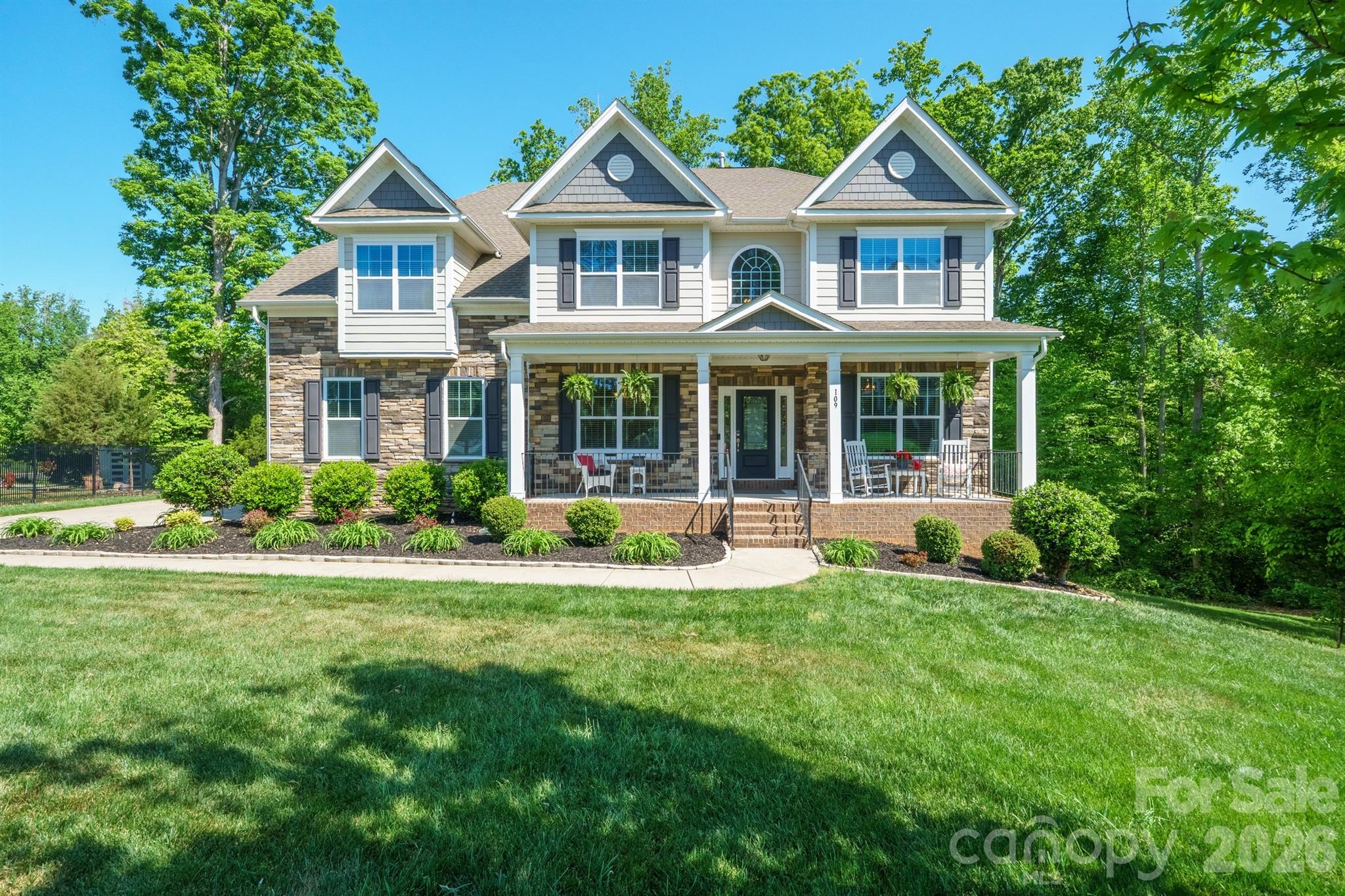 Welcome to refined comfort in Shinnville Ridge, Mooresville.

Set within one of Mooresville's most desirable communities, this beautifully maintained 6-bedroom, 5.5-bath residence sits on over half an acre and delivers an exceptional balance of elegance, flexibility, and everyday livability.

From the moment you arrive, the home's curb appeal makes a strong impression. Classic stone accents complement the hardboard siding, while a wide driveway leads to a 2-car garage.

The outdoor living spaces are equally inviting, featuring a walkout basement and a fully screened-in deck with a serene, "tree-house" feel overlooking the fire pit and tree line - an ideal backdrop for either lively gatherings or quiet evenings at home.

Inside, the main level offers generous side rooms, a full bedroom and bath well suited for guests or multigenerational living, and an expansive open-concept layout connecting the kitchen, living room, and breakfast nook. The kitchen truly shines, showcasing matching stainless-steel appliances, beautiful white cabinetry, a spacious walk-in pantry, and a stylish butler's coffee bar that adds both function and personality.

The upstairs level is thoughtfully designed with four additional bedrooms, a large and versatile bonus room, and a conveniently located laundry room. The primary suite serves as a private retreat, featuring its own lounge area, two walk-in closets, and an additional closet or sitting space for added flexibility. The spa-inspired bath elevates everyday routines with a soaking tub, fully tiled shower, and private water closet.

The fully finished basement expands the home's possibilities even further and could easily function as a home within a home. A very spacious living area is complemented by multiple bonus rooms ideal for a studio, gym, office, or theater, along with a private bedroom and full bath. Whether you envision a photography studio, golf simulator, or an exceptional space for entertaining or hobbies, this level is ready to adapt to your lifestyle.

Conveniently located near shopping, dining, and major highways, this home delivers space, comfort, and versatility in a sought-after Mooresville setting. Come experience a home designed to grow with you - and to impress at every turn.