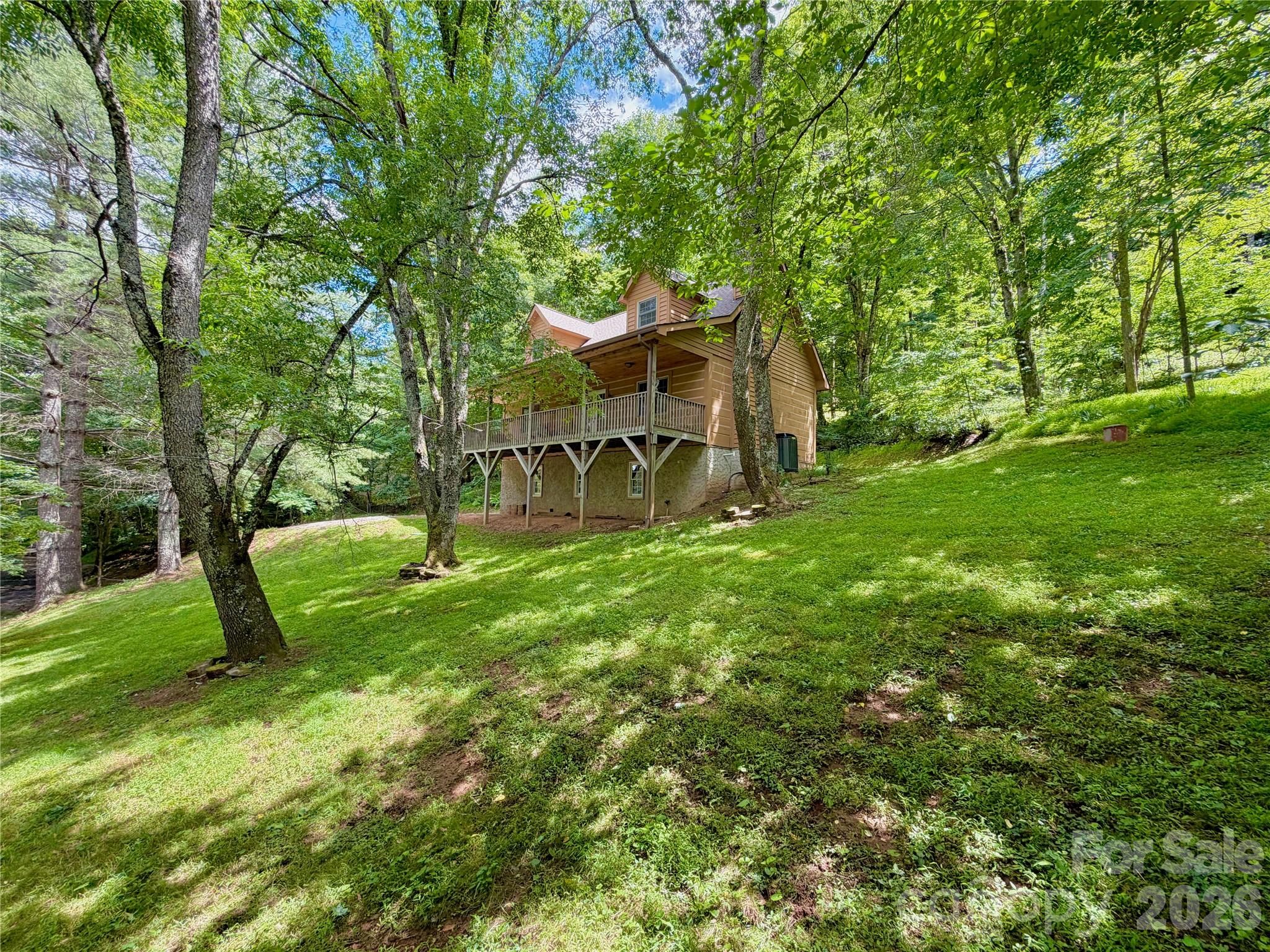 Enjoy the best of the High Country from 219 Red Maple Lane, a well-kept log cabin tucked into a convenient mountain setting just 10 minutes from Boone, NC. Whether you are looking for a full-time residence or a part-time mountain getaway close to the best of the area, this home offers the perfect blend of rustic charm, practical living space, and easy access to town, dining, shopping, outdoor recreation, and Appalachian State University. The main level features hardwood floors and an open-concept living, kitchen, and dining area. The stone wood-burning fireplace is perfect for cool nights with the potential to convert to propane if desired. The spacious primary bedroom is also located on the main floor and includes an en-suite bathroom and large walk-in closet. A guest half bath adds convenience, while double doors from the living area open to a generous 320-square-foot covered deck—perfect for relaxing, entertaining, or enjoying the mountain setting. There is also a rear grilling deck located just off the kitchen. Upstairs, you’ll find two large bedrooms with vaulted ceilings and a full bathroom, providing plenty of space for family, guests, or a home office setup. The home also offers generous storage space throughout, making it easy to enjoy mountain living without sacrificing functionality. Important updates include a central heating and air system replaced in 2023 and a roof replaced in 2024. A major bonus is the large 917-square-foot unfinished basement/garage with windows and driveway access. This flexible space is ideal for multiple cars, a workshop, tools, outdoor gear, toys, storage, and more. Outside, the property offers plenty of parking along with a large grassy yard area. Located a short drive from the New River, Todd, Elk Knob State Park, restaurants, shopping, and all the amenities of Boone, 219 Red Maple Lane combines classic log cabin appeal with practical space, recent updates, and easy access to the best of the High Country.
