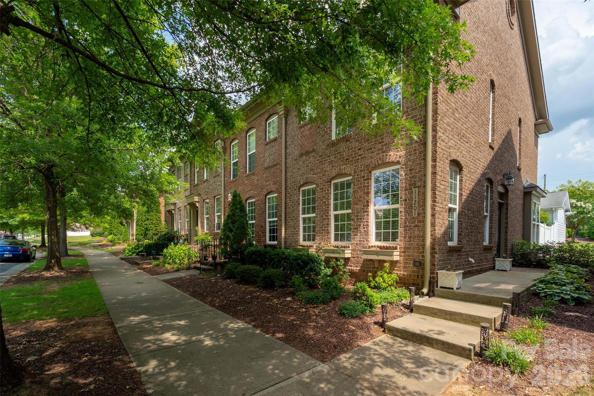 Welcome to this beautifully maintained full brick end-unit townhome in the highly sought-after Cedar Walk community in Ballantyne! Filled with natural light, this move-in ready home features an open floor plan with gorgeous wide plank hardwood floors throughout the main level. The spacious eat-in kitchen offers granite countertops, a stylish backsplash (2021), stainless steel LG appliances (2023), and a bright breakfast area perfect for everyday living. Upstairs, you'll find two spacious primary suites, each with a private bath and walk-in closet, including one with a custom closet system. Recent updates include new carpet, custom laundry room shelving, and upgraded bronze switch and outlet covers. Enjoy the privacy of a fenced backyard with a large patio and the convenience of an extra-wide one-car garage. Security-treated main-level windows provide added peace of mind, while low utility costs make everyday living even more enjoyable. Ideally located within walking distance of shops and restaurants and just minutes from The Bowl at Ballantyne, Blakeney, and Indian Land, SC, this home offers exceptional convenience in one of Charlotte's most desirable locations.