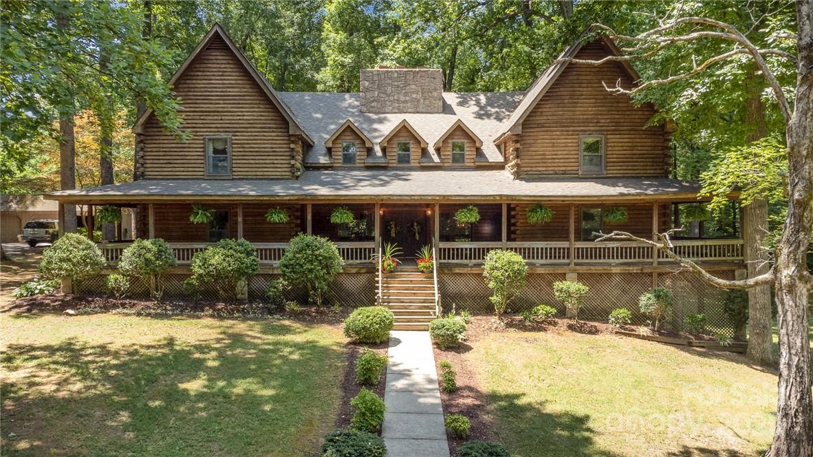 Welcome to Meadow Lane, a breathtaking custom built log home with picturesque views nestled on over 5 acres with custom features throughout the home, where luxury awaits you. From rocking on the oversized front porch, to lounging by the pool, this property provides beautiful woodwork with specialty details throughout. The enormous wrap around porch and extended back porch area exceeds over 2500SF surrounded by nature views. The fieldstone rock wood burning fireplace is the centerpiece of the home. The primary BR complete with sitting area, dressing area, double walk in closets, leading to the ensuite bath provides a quiet oasis. The gourmet kitchen includes a kitchen island, eat at bar, & stainless steel appliances. The home includes multiple spaces that can serve as work space, entertaining or workout spaces. The garage has a wired workshop and bays for parking. Less than 5 minutes from I-85, this retreat is a must see! Home is priced below last appraisal.