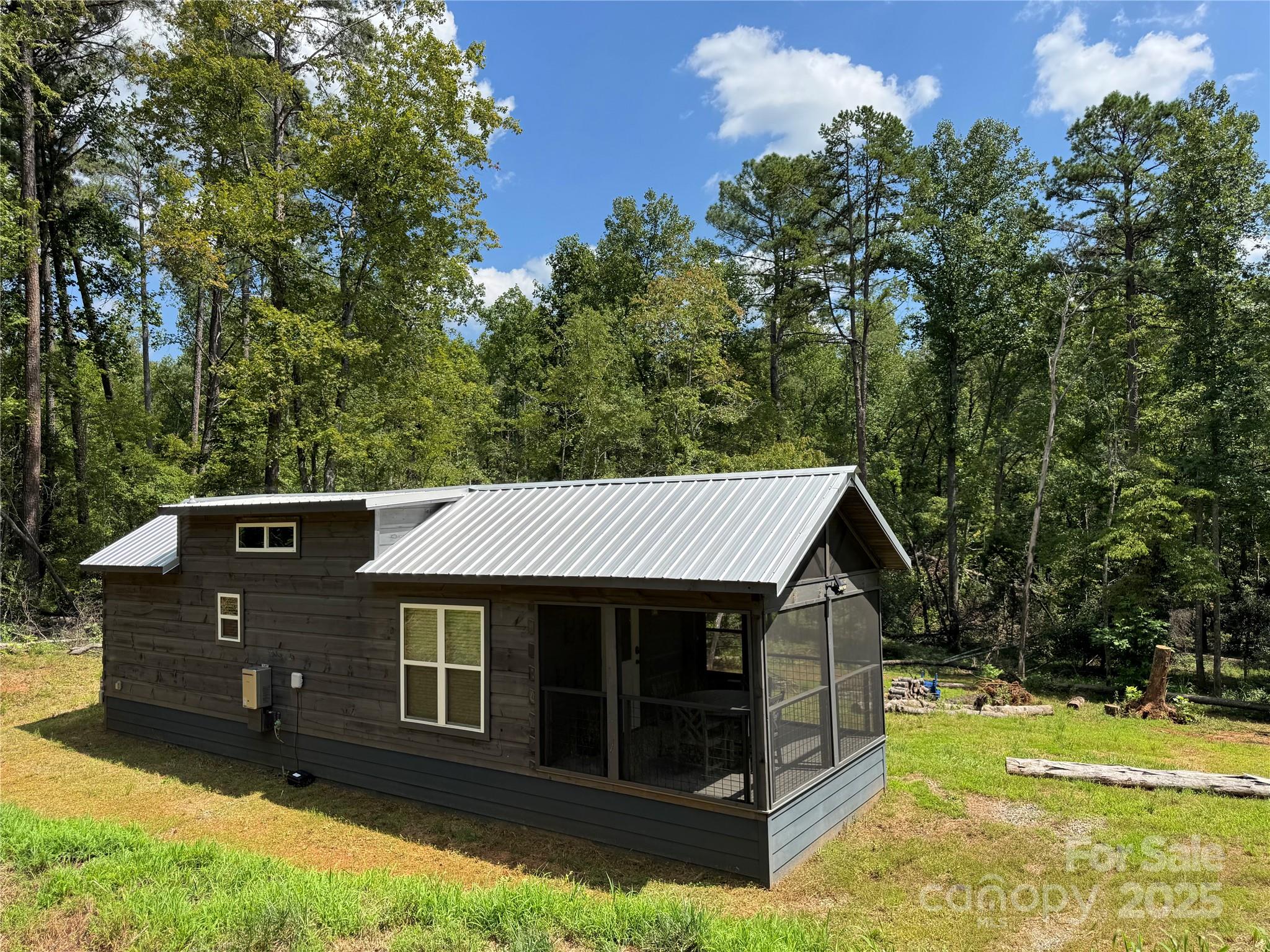Escape to this charming Green River Log Cabin, perfectly situated on 2.23 private acres in Lake Lure. This serene mountain retreat features a creek and fire pit, creating the perfect mountain getaway setting. Designed with custom finishes, this turnkey cabin offers an open floor plan with cathedral ceilings, a Queen-size bed featuring integrated under-bed storage, sofa bed in the family room, a convenient laundry area, and additional sleeping space with twin beds in the loft. The screened deck, finished with durable Trex, is ideal for outdoor entertaining while keeping the elements at bay. Whether you're seeking a personal getaway or an income-producing Airbnb, this exquisite Green River Log Cabin blends charm, comfort, and investment potential. Notably, the property is equipped with a 4-BEDROOM MULTI BATH SEPTIC SYSTEM, providing flexibility for future expansion!