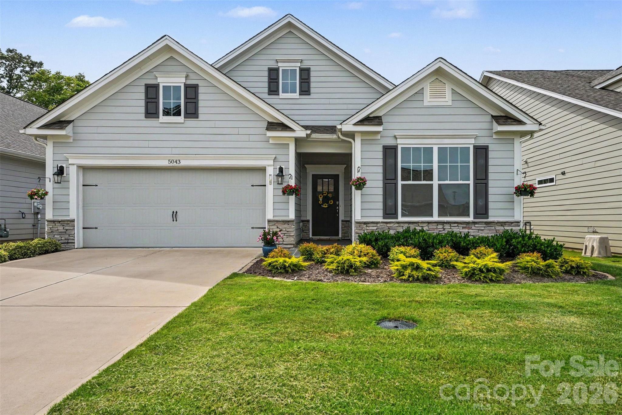 Welcome to 5043 Antebellum Drive, a beautifully appointed home in one of Denver's most sought-after 55+ active adult communities. Combining luxury, convenience, and a low-maintenance lifestyle, this move-in-ready home offers the perfect opportunity to enjoy all that the Lake Norman area has to offer.

From the moment you arrive, lush landscaping and a custom stone walkway create a warm and inviting first impression. Inside, this thoughtfully designed 3-bedroom, 2-bath home features an open-concept floor plan enhanced by luxury vinyl plank flooring, crown molding, picture-frame accents, and abundant natural light throughout. A versatile bedroom with elegant French doors provides the perfect space for a home office, hobby room, or guest retreat.

The gourmet kitchen is the heart of the home, showcasing quartz countertops, stainless steel appliances, a spacious center island, and ample cabinetry—ideal for entertaining guests or enjoying quiet mornings at home. The spacious primary suite serves as a private retreat, offering peaceful wooded views, a spa-inspired bath, and a walk-in closet with direct access to the laundry room for everyday convenience.

Step outside to the private rear patio and enjoy serene views of the natural area behind the home, creating the perfect setting for morning coffee or relaxing evenings.

Beyond your front door, an exceptional active adult lifestyle awaits. Residents enjoy resort-style amenities including pickleball courts, a fitness center, swimming pool, clubhouse, walking trails, and a full calendar of social activities designed to foster connection and community. With a low HOA covering exterior maintenance and community amenities, you'll have more time to travel, explore, and enjoy the activities you love.

Ideally located just minutes from shopping, dining, medical facilities, and everyday conveniences, this home is only 4 miles from beautiful Lake Norman, approximately 22 miles from Uptown Charlotte, and about 20 minutes from Charlotte Douglas International Airport. Whether you're seeking an active lifestyle, a downsizing opportunity, or the perfect retirement home near Lake Norman, this exceptional property offers the ideal blend of comfort, convenience, and community.

More than just a home, 5043 Antebellum Drive offers a lifestyle centered around wellness, connection, and carefree living.
