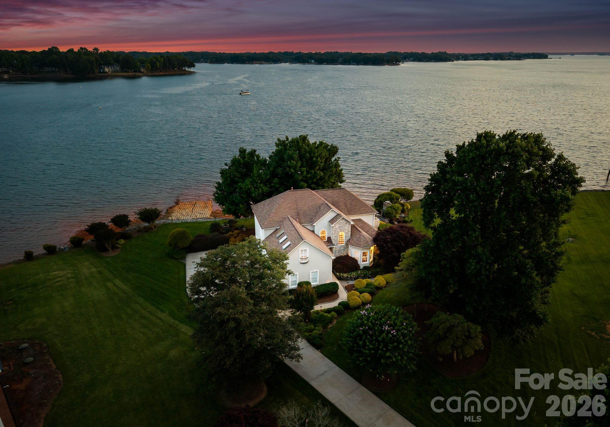 A rare opportunity to own a true Lake Norman waterfront retreat inside gated Westview, offering nearly 200 feet of shoreline, long-range sunset views, and deep-water dock access. Set in one of Mooresville’s most convenient lakefront corridors, this property combines privacy, water presence, and everyday lifestyle with quick access to LangTree, I-77, Davidson, golf, dining, marinas, and the best of Lake Norman living.

From the moment you arrive, the setting feels private, peaceful, and elevated. Wide water views, mature trees, sunset exposure, a cul-de-sac location, and a deep-water dock with sitting area create a waterfront experience that is increasingly difficult to find. The home has been carefully maintained and thoughtfully designed for natural light, comfort, and connection to the water, while still offering future owners room to personalize over time.

The sunroom functions as a true four-season lake room, capturing lake views and natural light in one of the home’s most valuable daily living spaces. The main living areas feel warm, functional, and easy to live in, with a natural flow for everyday living, hosting, and weekend gatherings. Outdoor living is equally compelling, with quiet mornings by the water, sunset evenings from the dock, mature landscaping, irrigation, a private backyard, and spaces designed for relaxed entertaining.

Westview offers gated privacy off LangTree Road, minutes from LangTree’s restaurants, events, and lake area conveniences, with quick access to I-77 for Davidson, Mooresville, Charlotte, and the broader Lake Norman region. Trump National Golf Club Charlotte, The Point, waterfront dining, marinas, and boating destinations are all part of the surrounding lifestyle.

Offered at $2,690,000, this property stands out for buyers who understand that Lake Norman’s most valuable real estate is defined by shoreline, views, dock access, privacy, and location. A rare Westview lakefront package with immediate lifestyle enjoyment, meaningful long-term ownership appeal, and the kind of shoreline, view, and privacy combination buyers should experience in person.