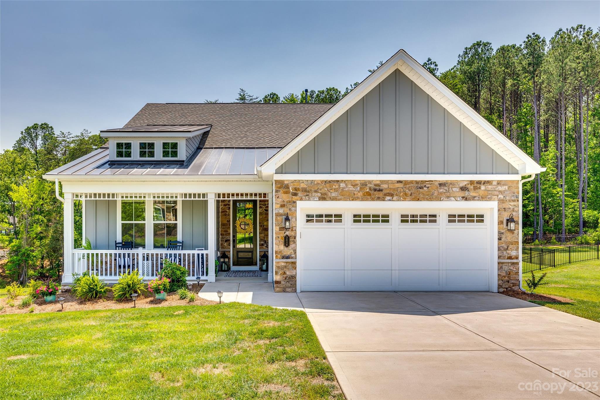 Welcome to Handsmill on Lake Wylie! Don't let this cozy cottage exterior fool you! With over 2100sqft of main level living, and an incredible walk out basement, you may be tempted to call this your vacation home! Lounge on the covered deck with your morning coffee or host an outdoor dinner party. There is room enough for all! The 1/2acre lot is fenced with a completely wooded back drop. Private and serene. Inside, the expansive kitchen is open to the great room and faces the rear outdoor living space. Located just off the garage entry, is the ultimate in convenience. An elevator to transport those heavy items to the second kitchen and rec-room below.  Soaring ceilings and oversized windows add to the bright and airy feel of the lower level. Owner is currently using the theatre room as a fourth bedroom. Plenty of storage options too with walk-in closets and a separate room just for stuff! Handsmill on Lake Wylie offers a clubhouse, pool, playground, & lake access for their residents.