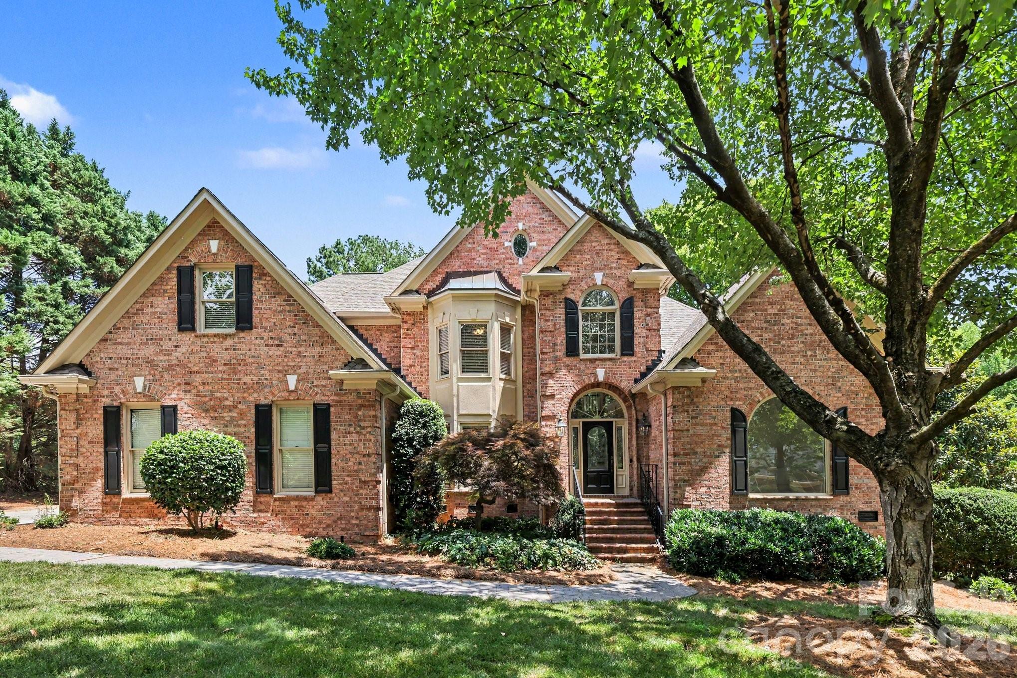 Prestigious Providence Country Club living meets timeless design in this classic all-brick home perched to overlook the 5th green. This 4 bedroom, 3.5 bath home features soaring ceilings, radiant natural light, and warm hardwood floors set against neutral finishes that create a refined backdrop for everyday living and entertaining. The open, inviting living spaces flow into a stunning kitchen equipped with quartz countertops, stainless appliances, and custom cabinetry, ideal for both daily meals and sophisticated gatherings. The main level hosts a spacious primary suite with an oversized en-suite bath and large walk-in closets, plus a peaceful sitting area. A second-floor office provides a quiet work-from-home area, along with an optional 5th bedroom or bonus space to adapt to your needs. Outside, a covered back terrace invites relaxed outdoor living while enjoying tranquil views of the green. This home offers a superb balance of luxury, comfort, and versatility in a premier neigh