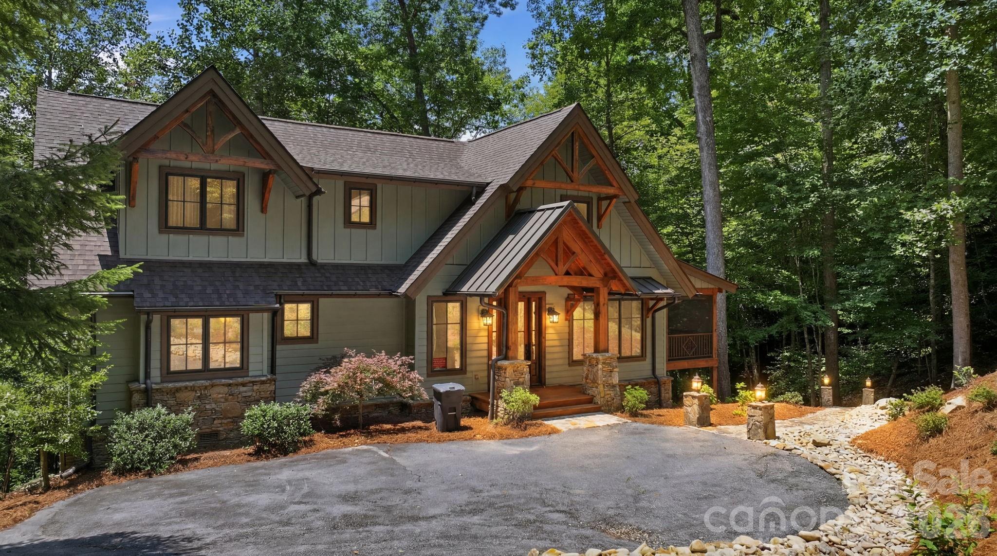 A classic mountain sanctuary nestled within the exclusive Bear Lake Reserve, this three bedroom, two and a half bath home offers approximately 2,350 square feet of refined living space on a 1.93-acre lot. Accessed via the community's private road, this residence epitomizes mountain privacy and serenity. The home showcases beautiful gable-end architecture with exquisite stone rockwork and a welcoming covered porch featuring bug screening and clear vinyl panels. Inside and out, an elegant stone fireplace anchors the home, with the exterior element gracing the screened porch, perfect for year-round enjoyment. Recent updates include a new roof and siding installed in 2025. The lakefront setting reveals its magic through a graceful stone walkway descending to a private cove opening, complete with a fire pit for evening gatherings. A shared dock on the common property line provides water access via a landscaped path. Parking is accommodated by a paved pad above the home. The seller is offering a generous $25,000 credit toward dock repairs and a $40,000 credit toward club membership, exceptional value for the discerning buyer. This is a truly exceptional mountain retreat for those seeking privacy, natural beauty, and timeless elegance.