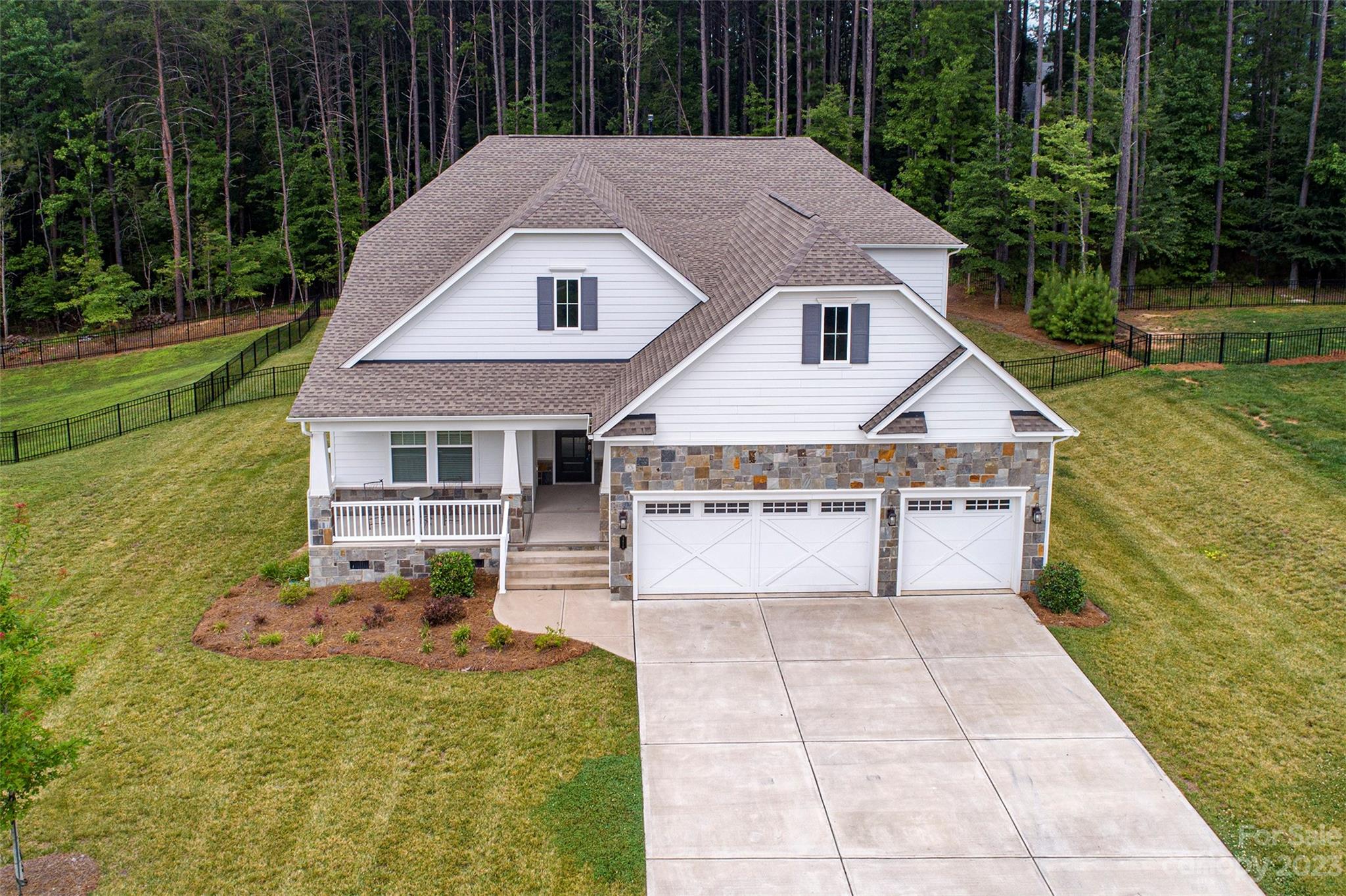 Built on one of the best lots in the community & almost new, this Mulberry floorplan offers the simplicity of a ranch home WITH the extra space you need. Walking in, you pass the covered front porch and are greeted by the LUXURY Vinyl Plank floors that cover all common areas for maintenance free living.  Downstairs includes an office w/French doors & two auxilary bedrooms, one with an en-suite bathroom.  The gourmet kitchen features a HUGE island, gas range, 42" cabinets w/crown molding & TWO pantrys!  Downstairs also includes a HUGE open-concept floorplan featuring a family room w/gas fireplace, eat-in kitchen & flex space for a dining area, game room or sunroom.  The primary bedroom offers a tres ceiling & space for a King Bed & your furniture.  The en-suite bath has an over-sized semi-frameless shower, double sinks & great natural light. Upstairs is a HUGE bonus/bedroom with en-suite full bath & walk-in storage room.
Outside your yard is fenced & includes a covered porch & deck.