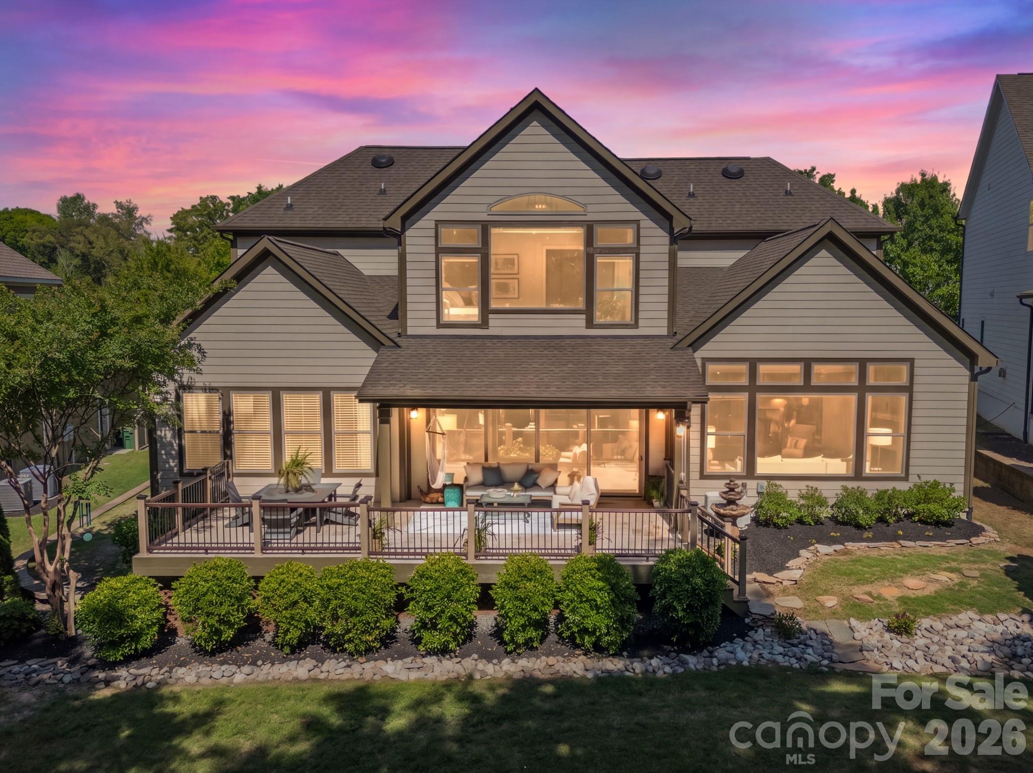 Stunning 5-bedroom, 4 full bath, 2 half bath home in the coveted Springfield community of Fort Mill, ideally positioned on the 13th green of the Springfield Golf Course. Thoughtfully designed for both everyday living and elevated entertaining, this home showcases an open-concept layout filled with natural light and refined architectural details throughout. A dramatic two-story foyer sets the tone, opening to an inviting floor plan anchored by a spacious family room with cathedral ceilings, a stacked stone fireplace, and a wall of windows framing picturesque backyard and golf course views. The chef’s kitchen serves as the heart of the home, featuring a large island with farmhouse sink, gas cooktop, split cooking design with double ovens, a walk-in pantry with custom built-ins, and new GE Café refrigerator and dishwasher. The adjacent dining area with built-in bar and beverage refrigerator, along with a light-filled sunroom with travertine flooring and sliding doors, enhances the home’s effortless flow for entertaining. The main level offers a luxurious primary suite with vaulted ceilings, a spa-inspired bath complete with garden tub, tiled shower, dual vanities, and a custom closet system. A private guest suite with en-suite bath, dedicated office with French doors and designer finishes, powder bath, and a well-appointed laundry room with custom cabinetry complete the main level. Upstairs, exceptional flexibility continues with three additional bedrooms, including a well-appointed secondary suite with a private sitting area, spa-inspired bath with heated floors, and a wall of windows overlooking the backyard. Another secondary bedroom features a spacious custom closet with a built-in washer and dryer, while the third offers its own en-suite bath. A versatile loft with convenient access to a powder bath along with walk-in attic storage offering excellent functionality and abundant storage options. Outdoor living is equally impressive, with a covered porch featuring a tongue-and-groove ceiling and travertine flooring, complemented by a deck designed for low maintenance, perfect for relaxing or entertaining while enjoying the serene backyard views. Additional highlights include hardwood flooring, custom designer lighting, a whole-house water filtration system, and a spacious 3-car garage with split configuration. A golf cart is included, enhancing the ease of enjoying the community’s amenities and golf lifestyle. Springfield offers a premier lifestyle with resort-style amenities including championship golf, clubhouse, pool, fitness center, tennis, pickleball, playgrounds, walking trails, and direct access with included membership to the Anne Springs Close Greenway. Conveniently located near I-77, Charlotte, and the airport, and zoned for top-rated Fort Mill schools.