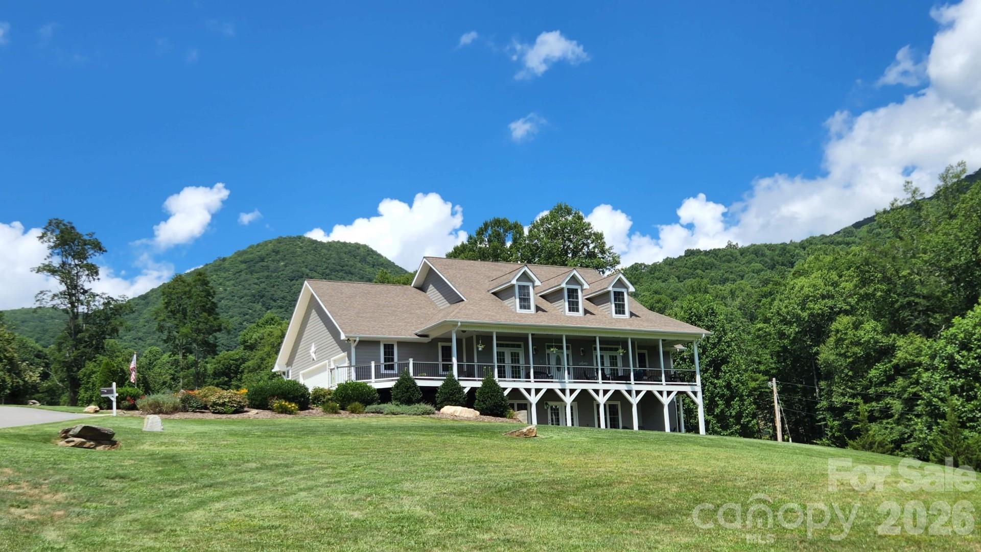 Exceptional 4-bedroom, 4.5-bath home offering over 4,000 square feet of beautifully designed living space, situated on 3 private acres in the peaceful countryside. With breathtaking mountain views and meticulously maintained grounds, this property delivers both luxury and tranquility. Inside, you’ll find spacious living areas ideal for everyday living and entertaining. Large windows bring in abundant natural light and showcase the surrounding scenery. The master on main and each of the bedrooms offer comfort and privacy, with ensuite baths. Step outside to enjoy expansive composite decking designed for low maintenance, complete with a hot tub, large firepit and multiple areas to relax and take in the views. The professionally manicured lawn creates a peaceful, park-like setting. Whether you’re looking for a full-time residence or a mountain retreat, this property offers the perfect blend of space, privacy, and natural beauty—all just a short drive to Waynesville and Asheville, NC.